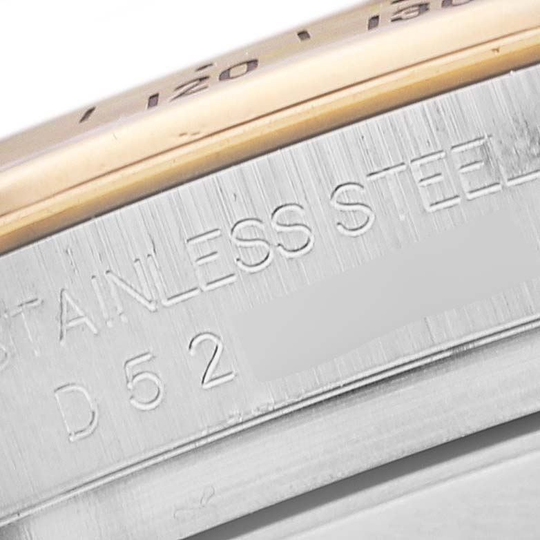 This is a close-up of the side of a Rolex Daytona 116523 Men's Steel and Gold (two tone) Mother of Pearl Dial 116523 Men's Steel and Gold (two tone) Mother of Pearl Dial watch, showing "STAINLESS STEEL" and part of the model number.