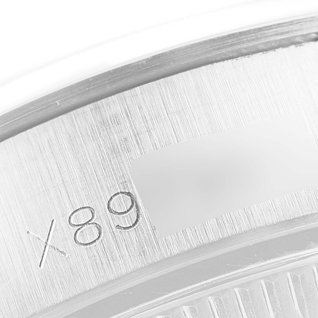 This close-up image shows a part of the case back of a Rolex Oyster Perpetual 67180 Women's Stainless Steel Black Dial 67180 Women's Stainless Steel Black Dial watch, highlighting the engraved serial number.