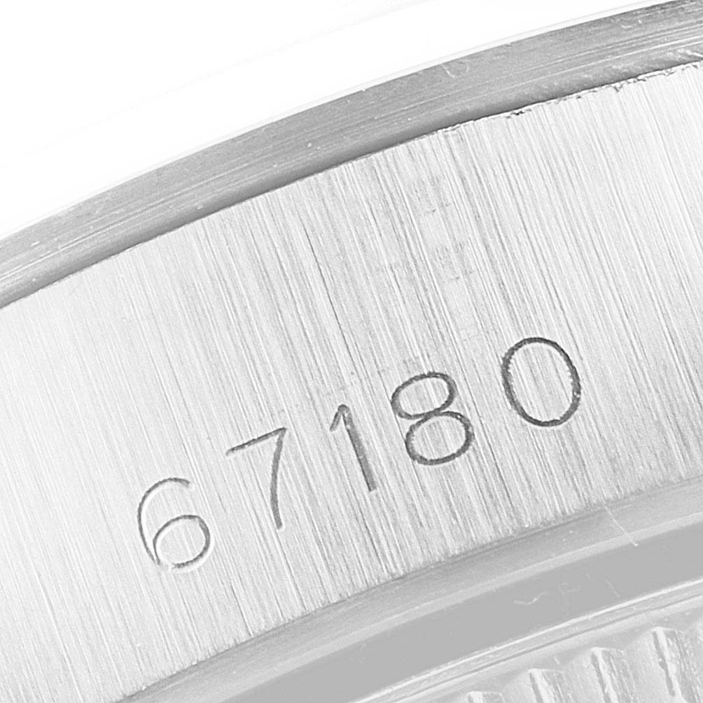 The image shows a close-up of the serial number engraving on the side of a Rolex Oyster Perpetual 67180 Women's Stainless Steel Black Dial 67180 Women's Stainless Steel Black Dial watch case.