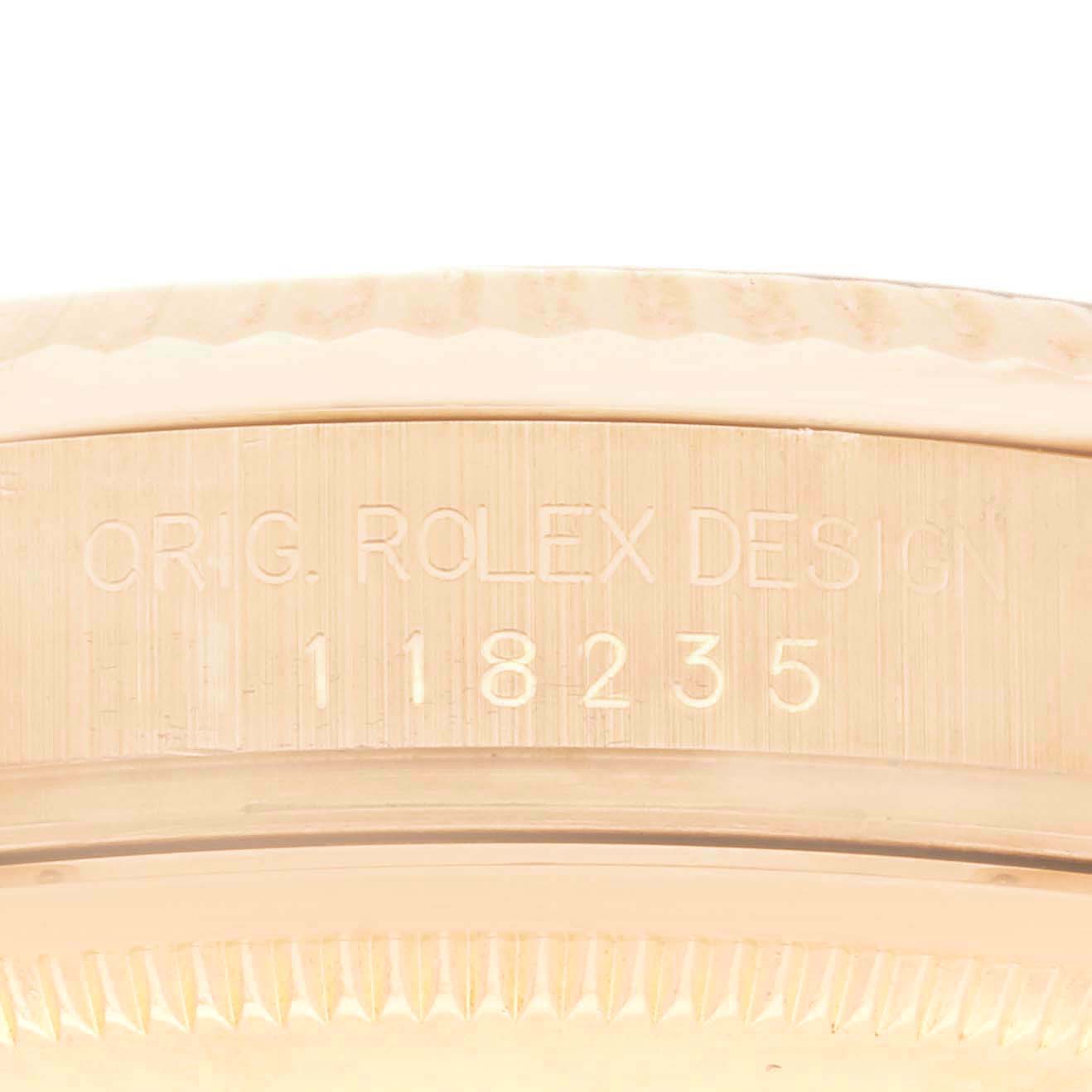 The image shows a close-up of the side of the Rolex President 118235 Men
s Rose Gold Pink Dial 118235 Men
s Rose Gold Pink Dial model watch with engraved design details.