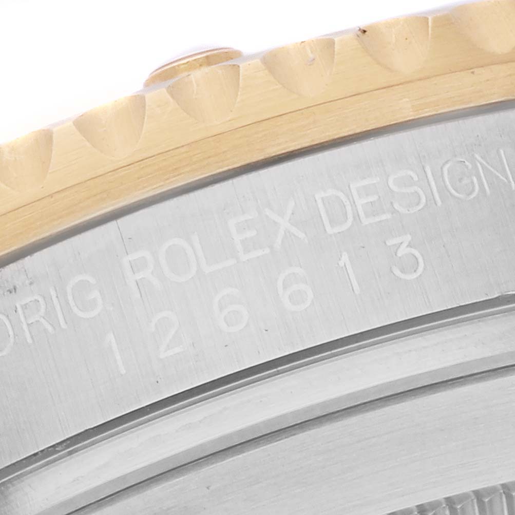 The image shows a close-up angle of the bezel and engraved case side of a Rolex Submariner 126613LB Men
s Steel and Gold (two tone) Blue Dial 126613LB Men
s Steel and Gold (two tone) Blue Dial watch.