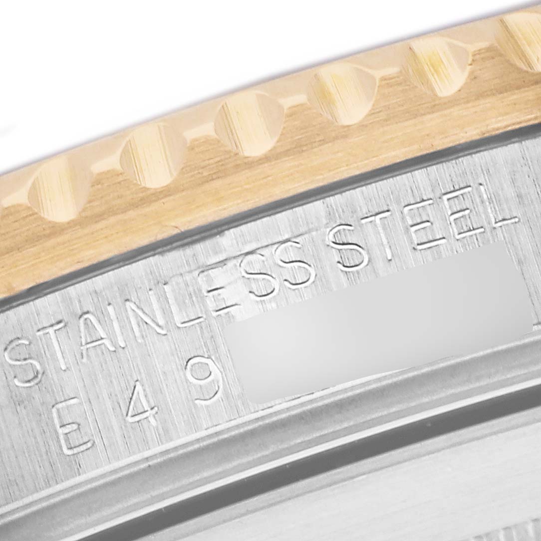 The image shows a close-up angle of the Rolex Submariner 16613 Men's Steel and Gold (two tone) Champagne Dial 16613 Men's Steel and Gold (two tone) Champagne Dial's bezel and casing with marked "STAINLESS STEEL."