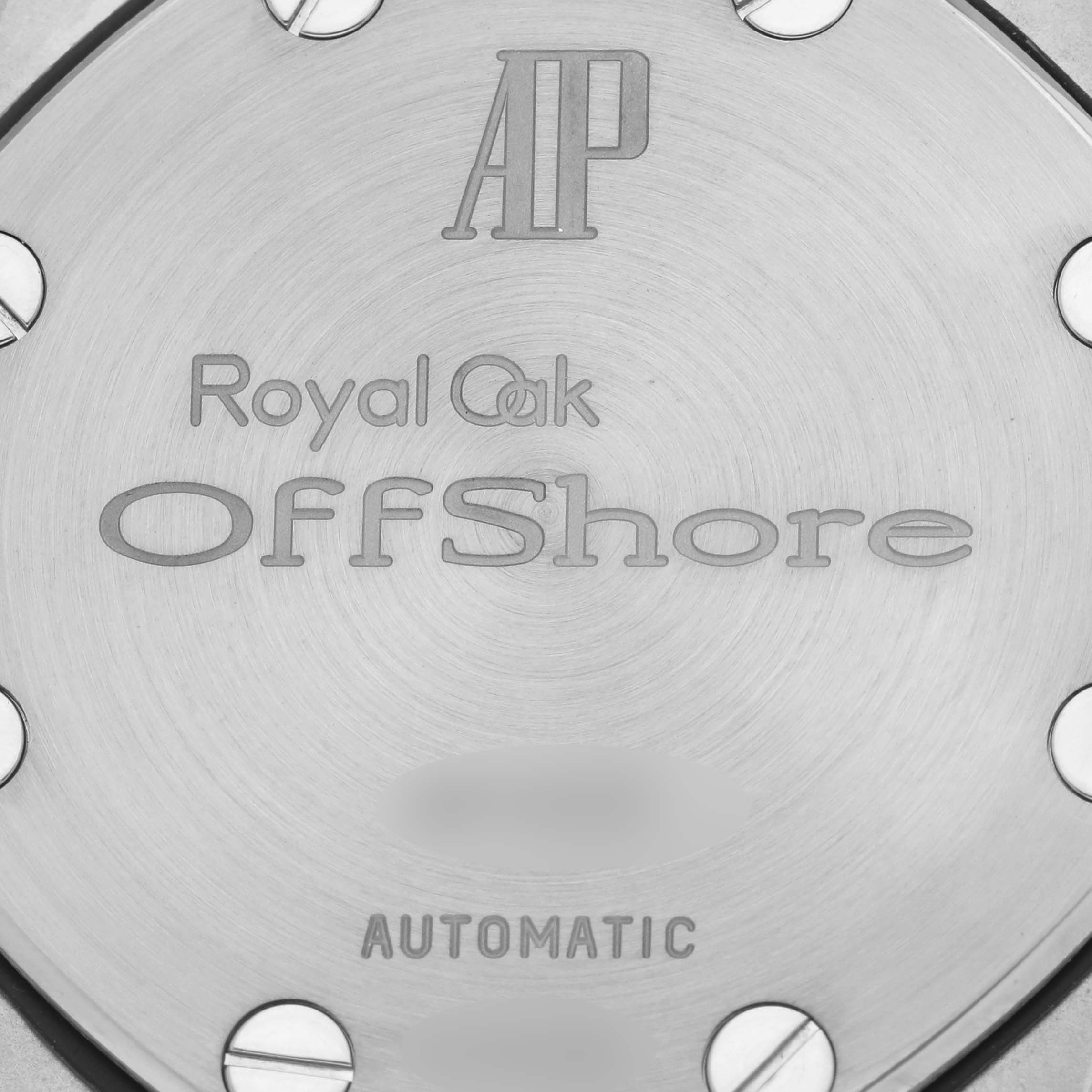The image shows the case back of an Audemars Piguet Royal Oak Offshore 25721ST.OO.1000ST.01 Men's Stainless Steel Blue Dial 25721ST.OO.1000ST.01 Men's Stainless Steel Blue Dial, highlighting engraved branding and screws.