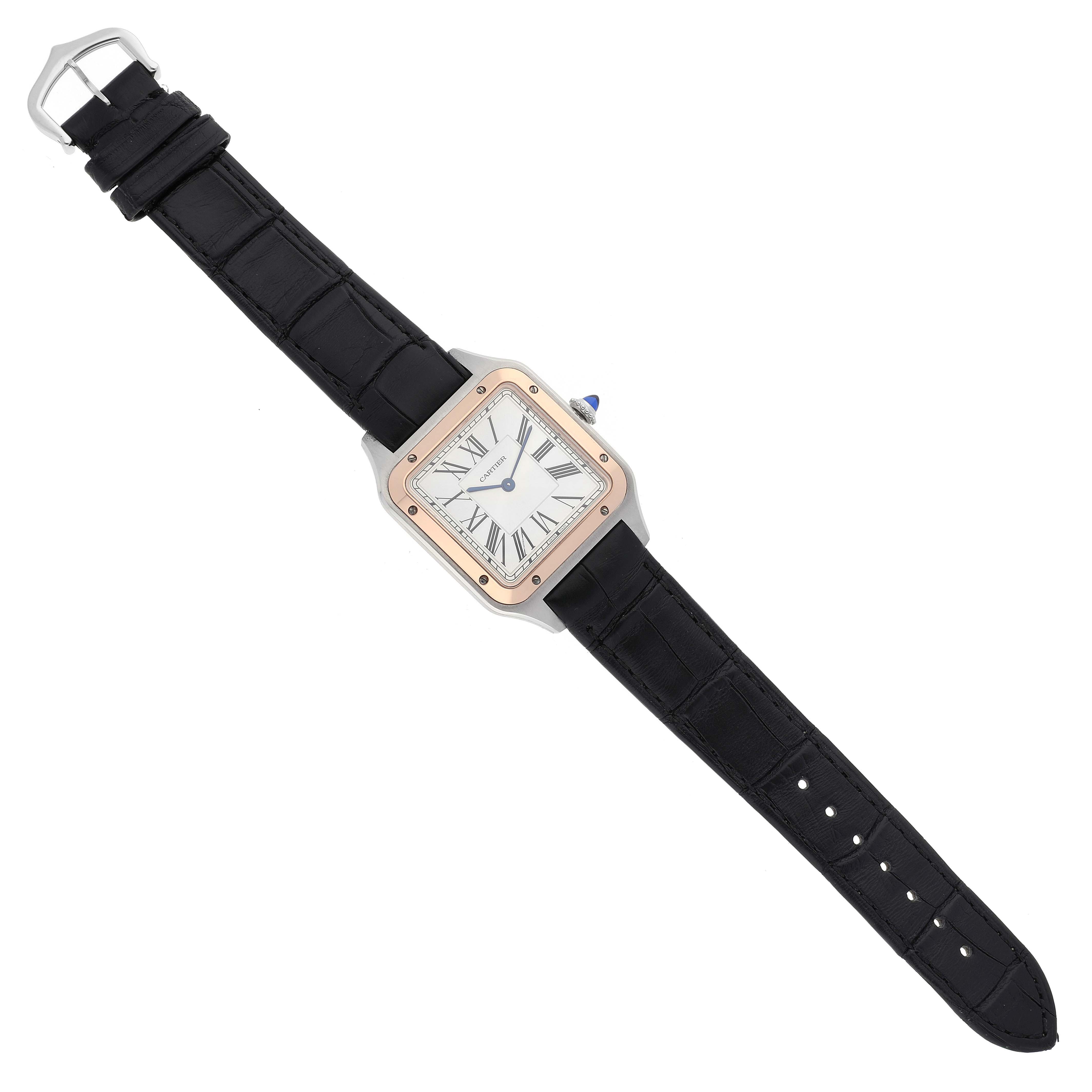 The image shows a top-down view of a Santos Dumont watch by Cartier, featuring a black strap and a square face with Roman numerals.