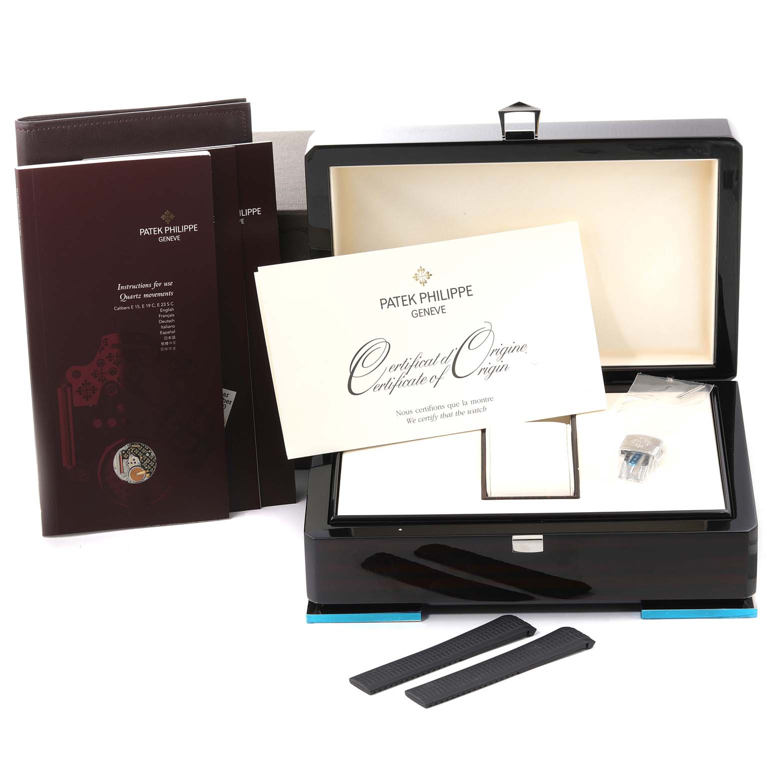 The image shows the packaging and accessories of a Patek Philippe Aquanaut 5167/1A-001 Men's Stainless Steel Black Dial 5167/1A-001 Men's Stainless Steel Black Dial, including a box, certificate, manuals, and spare parts.