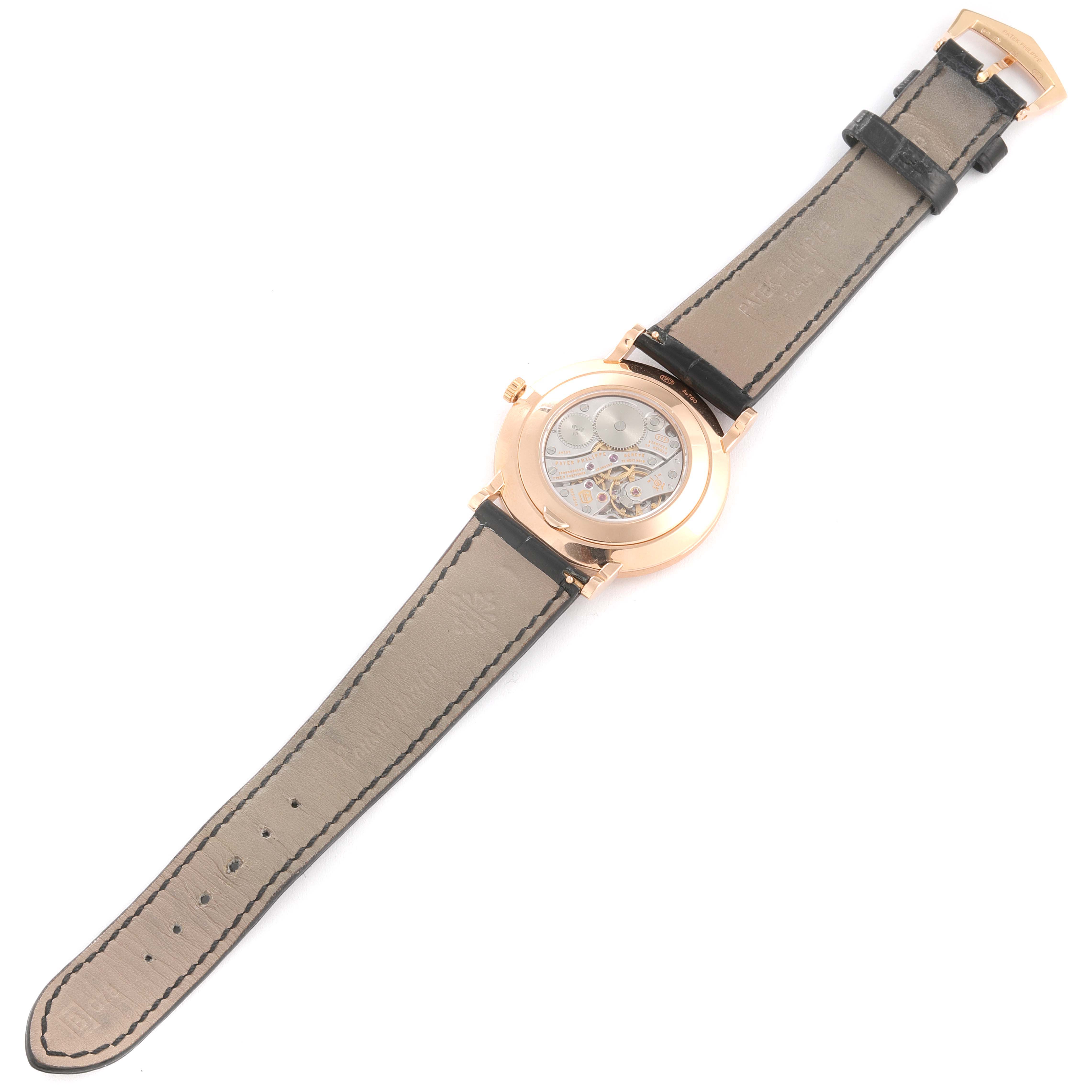 The image shows the back and strap of a Patek Philippe Calatrava 5116R Men
s Rose Gold White Dial 5116R Men
s Rose Gold White Dial watch, highlighting the movement through a transparent case back.