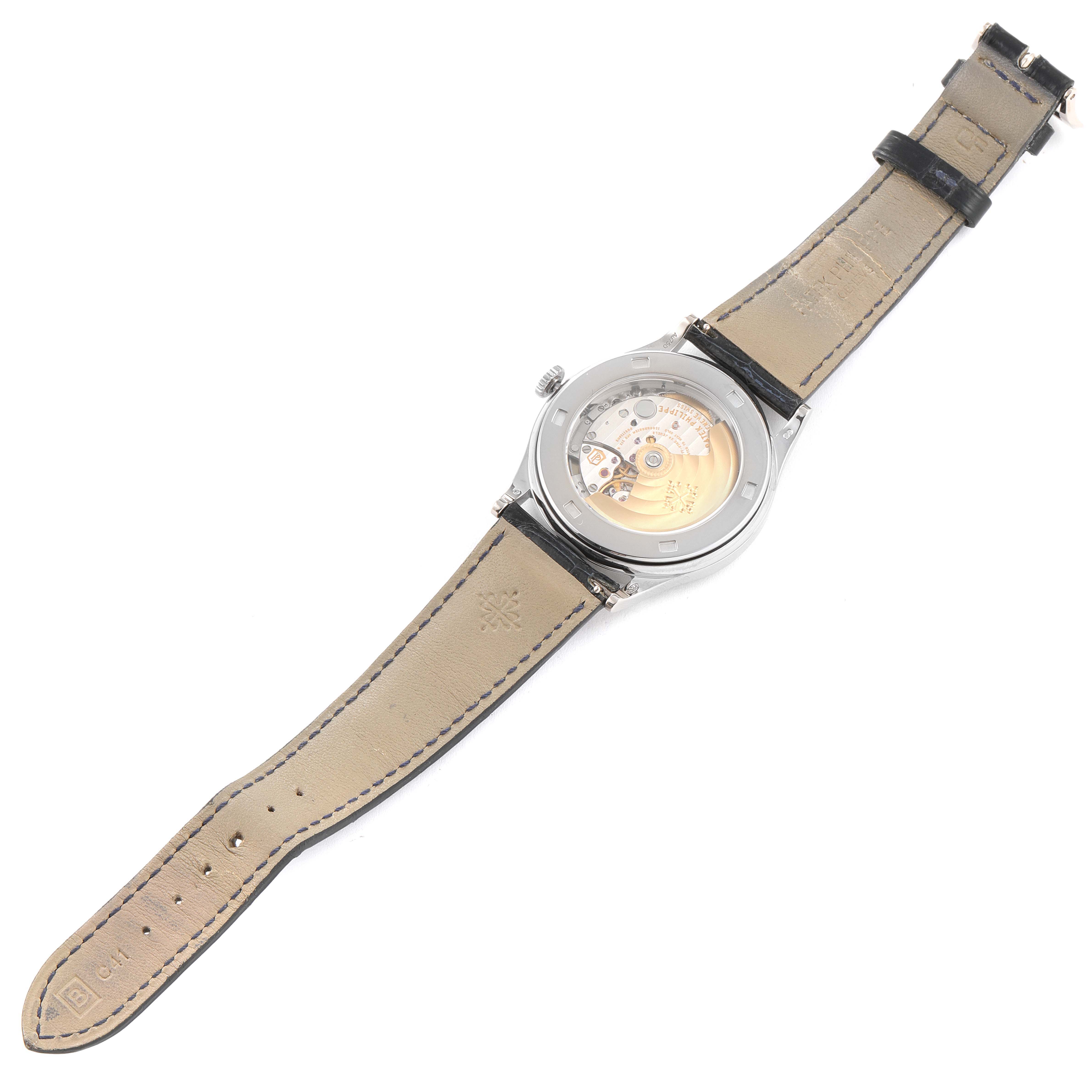 The image shows the back view of the Patek Philippe Calatrava 5296G-001 Men's White Gold Silver Dial 5296G-001 Men's White Gold Silver Dial watch, displaying its inner mechanism and leather strap.