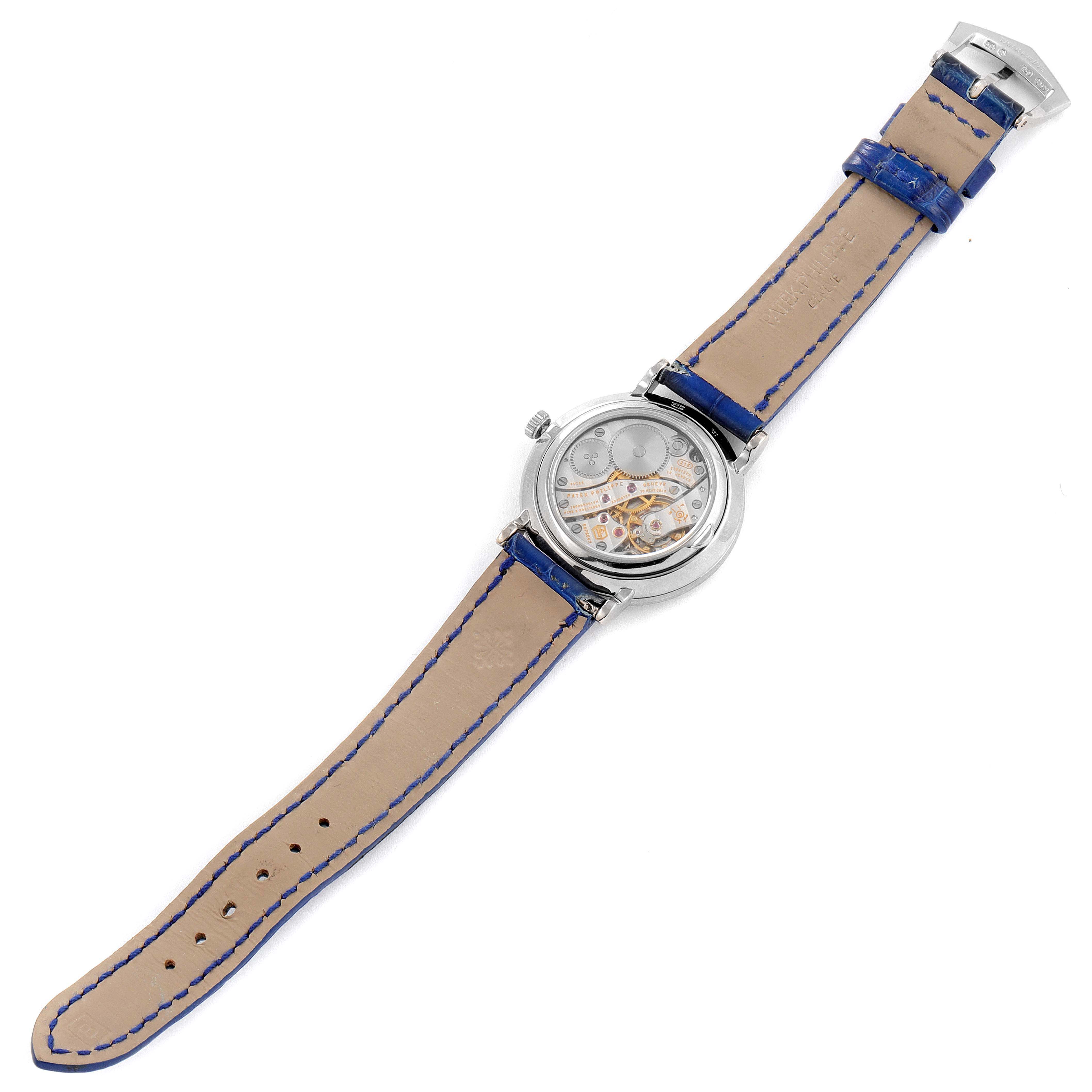 This image shows the back view of a Patek Philippe Calatrava 7120G Women's White Gold Beige Dial 7120G Women's White Gold Beige Dial watch, revealing its intricate inner mechanisms and blue leather strap.