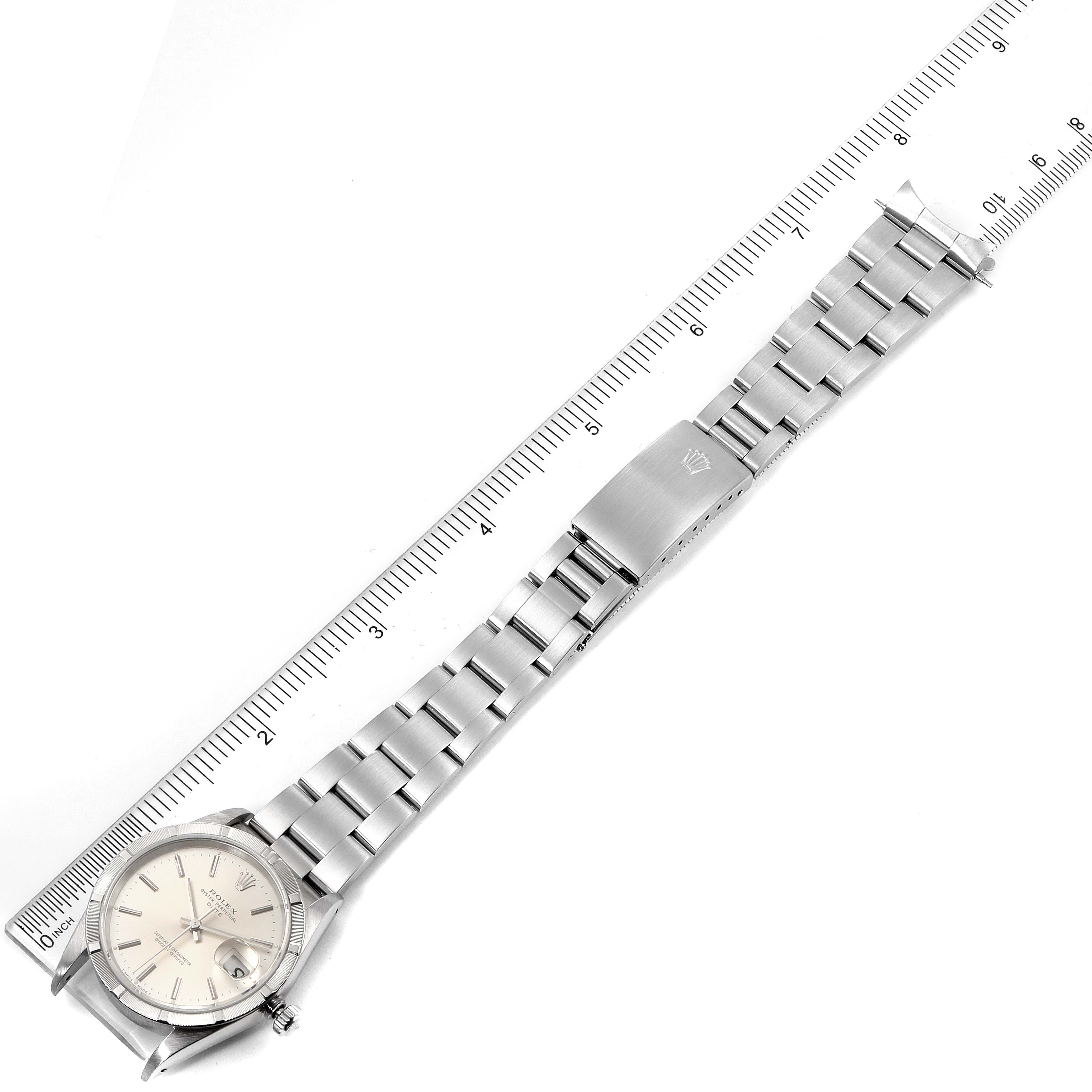 The image shows a top-down view of a Rolex Date 15210 Men's Stainless Steel Silver Dial 15210 Men's Stainless Steel Silver Dial model watch, highlighting the dial, bracelet, and clasp, alongside a measuring ruler.