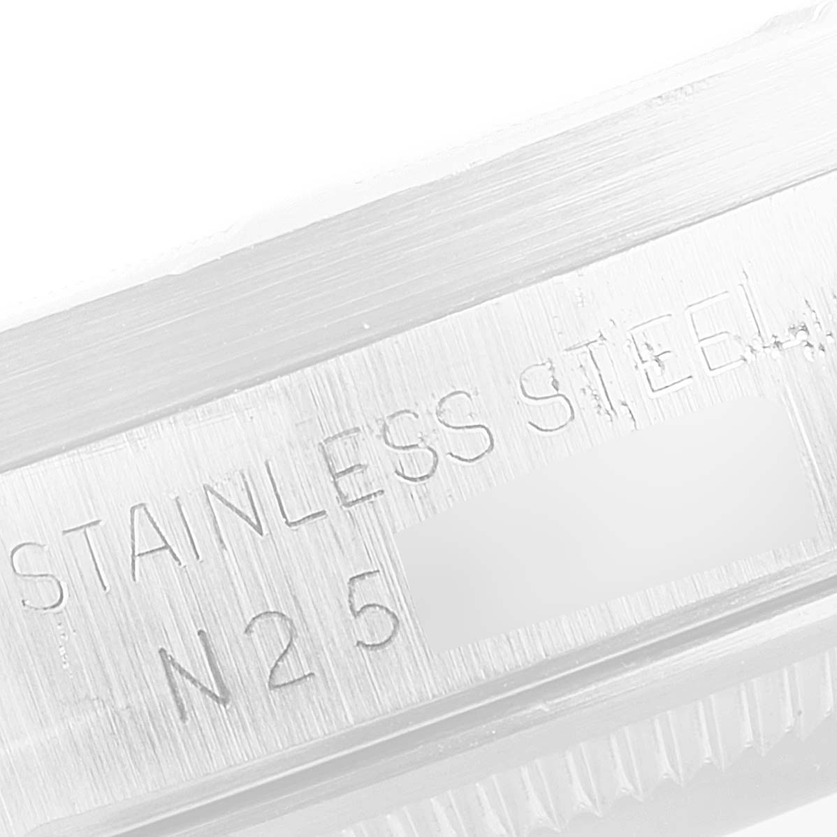 This image shows a close-up view of the "STAINLESS STEEL" engraving on a Rolex Date 15210 Men's Stainless Steel Silver Dial 15210 Men's Stainless Steel Silver Dial model watch.