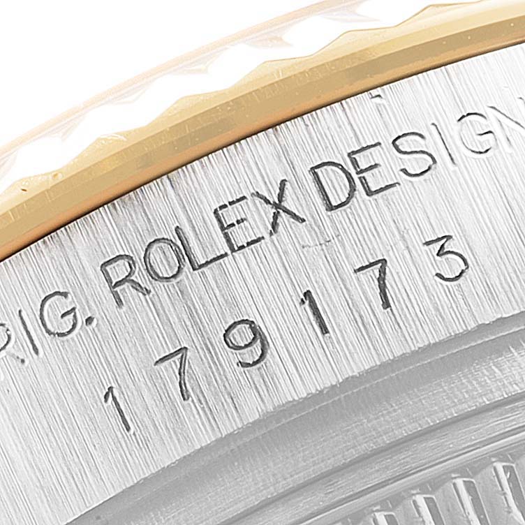 The image shows a close-up of the bezel and engraved serial number on a Rolex Datejust 179173 Women
s Steel and Gold (two tone) Grey Dial 179173 Women
s Steel and Gold (two tone) Grey Dial watch.