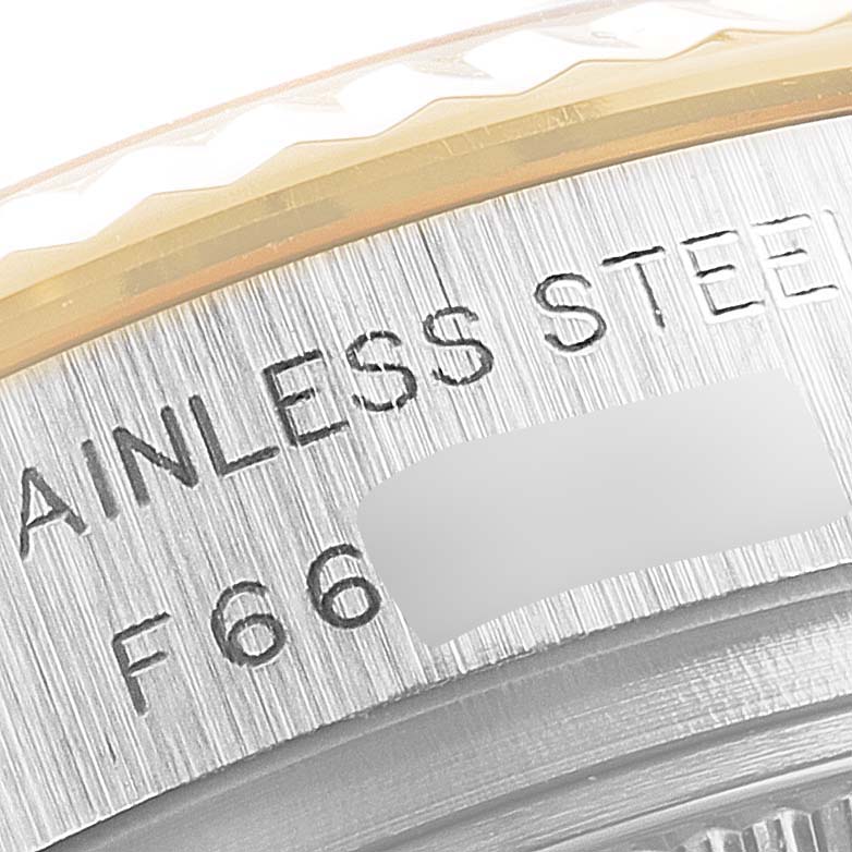 This close-up image of a Rolex Datejust 179173 Women
s Steel and Gold (two tone) Grey Dial 179173 Women
s Steel and Gold (two tone) Grey Dial watch shows the fluted bezel and the stainless steel case edge with engraved text.