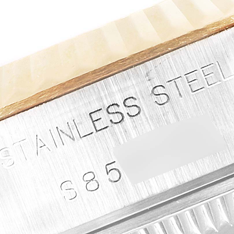 Close-up of the side of a Rolex Datejust 69173 Women
s Steel and Gold (two tone) Champagne Dial 69173 Women
s Steel and Gold (two tone) Champagne Dial, showing the fluted bezel and "STAINLESS STEEL" engraving.