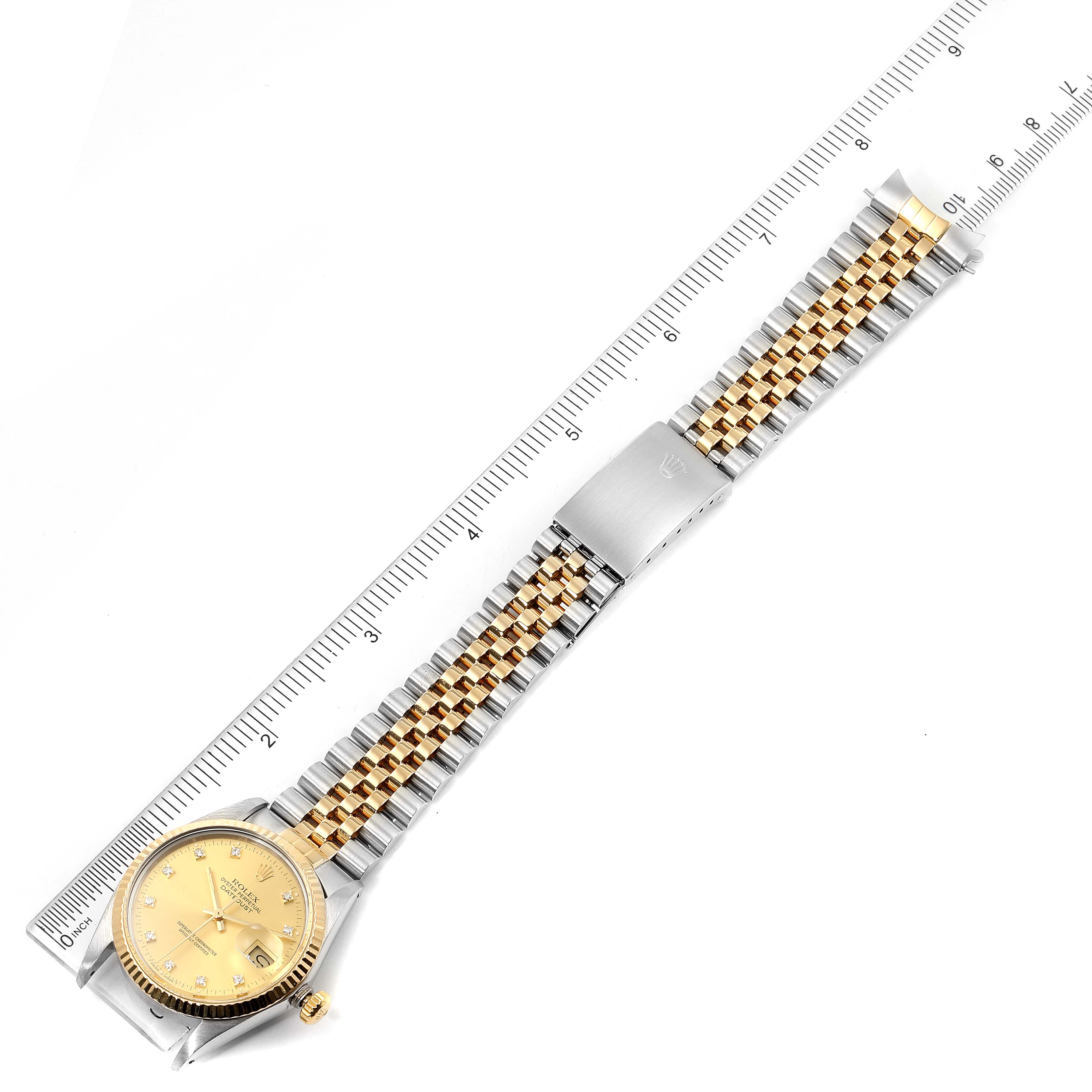The Vintage Collection Rolex watch is shown in a top-down view, displaying the face, bracelet, and clasp positioned along a ruler for scale.