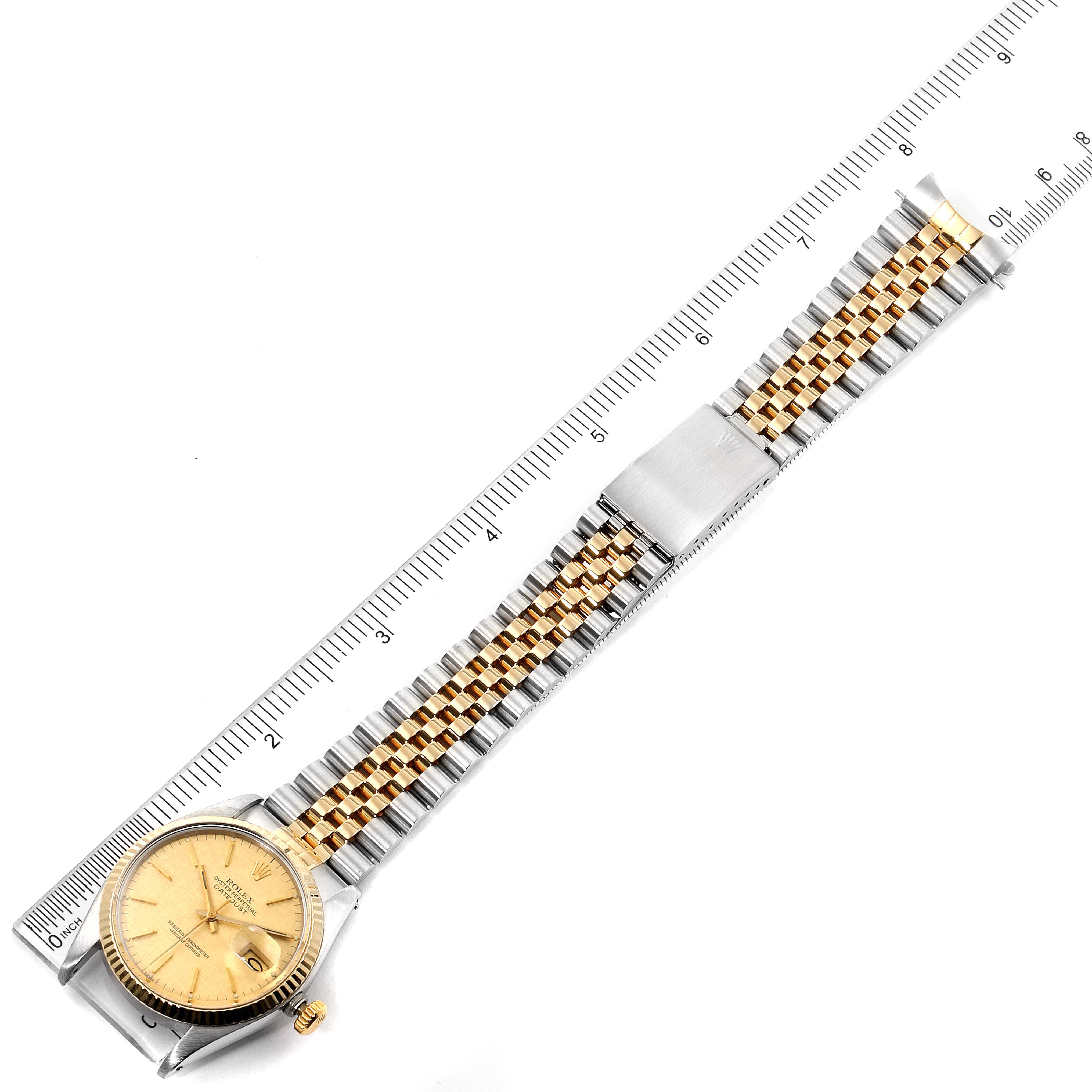 The Rolex Vintage Collection 16013 Men
s Steel and Gold (two tone) Champagne Dial 16013 Men
s Steel and Gold (two tone) Champagne Dial watch is shown from a top-down angle, displaying the face, bracelet, and clasp alongside a ruler for scale.