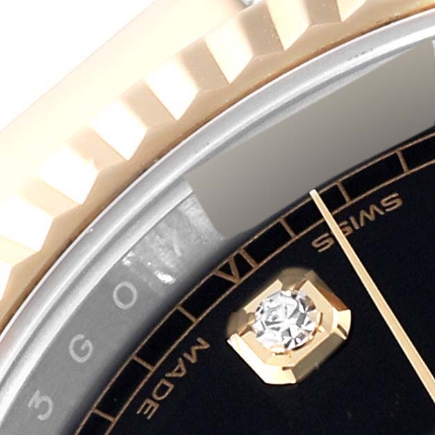 This close-up image of the Rolex Datejust 41 126333 Men's Steel and Gold (two tone) Black Dial 126333 Men's Steel and Gold (two tone) Black Dial shows part of the bezel, dial, gemstone hour marker, and minute hand.
