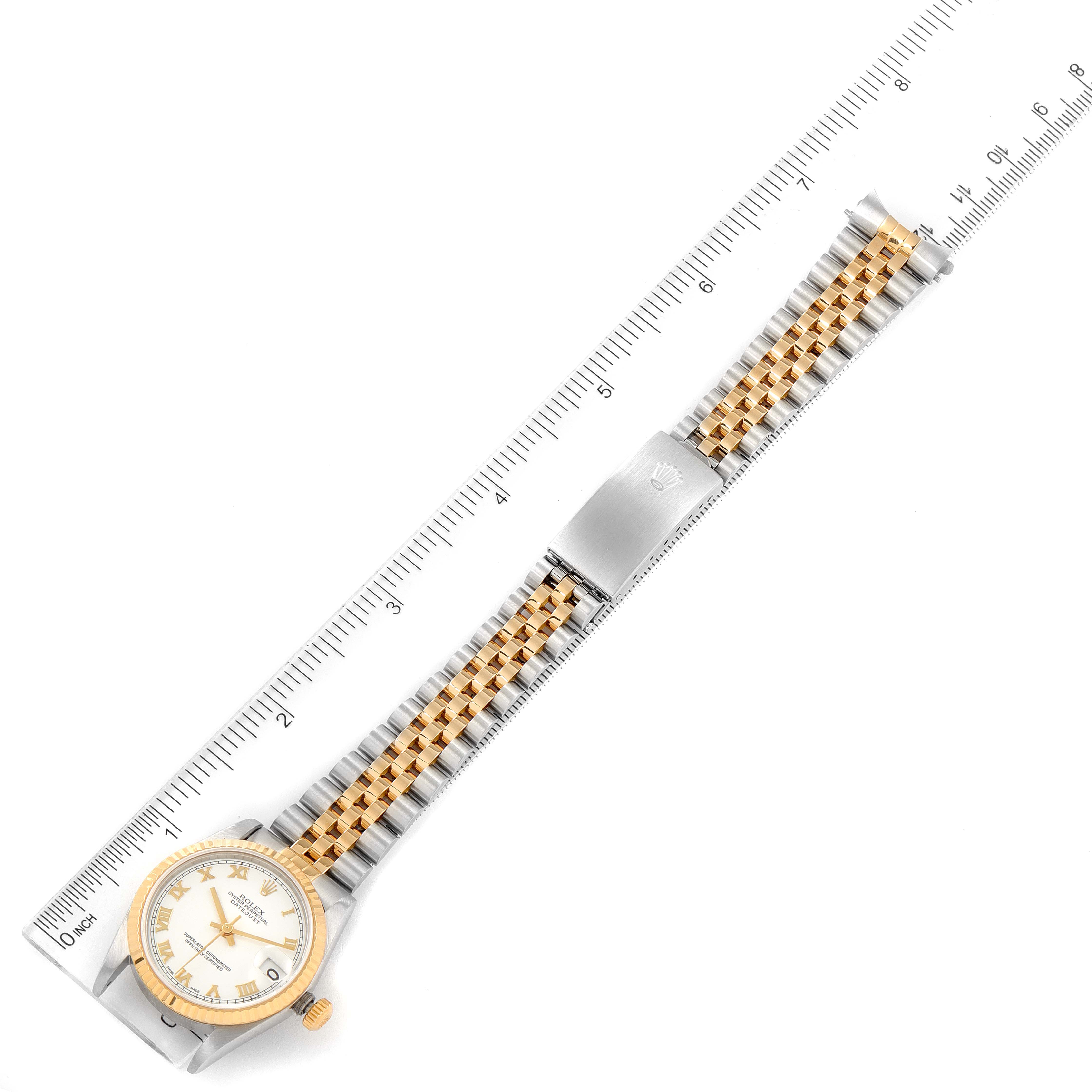 The Rolex Mid-Size 78273 Women
s Steel and Gold (two tone) White Dial 78273 Women
s Steel and Gold (two tone) White Dial watch is shown from a top-down angle, revealing the face, bezel, and full length of the bracelet, alongside a ruler.