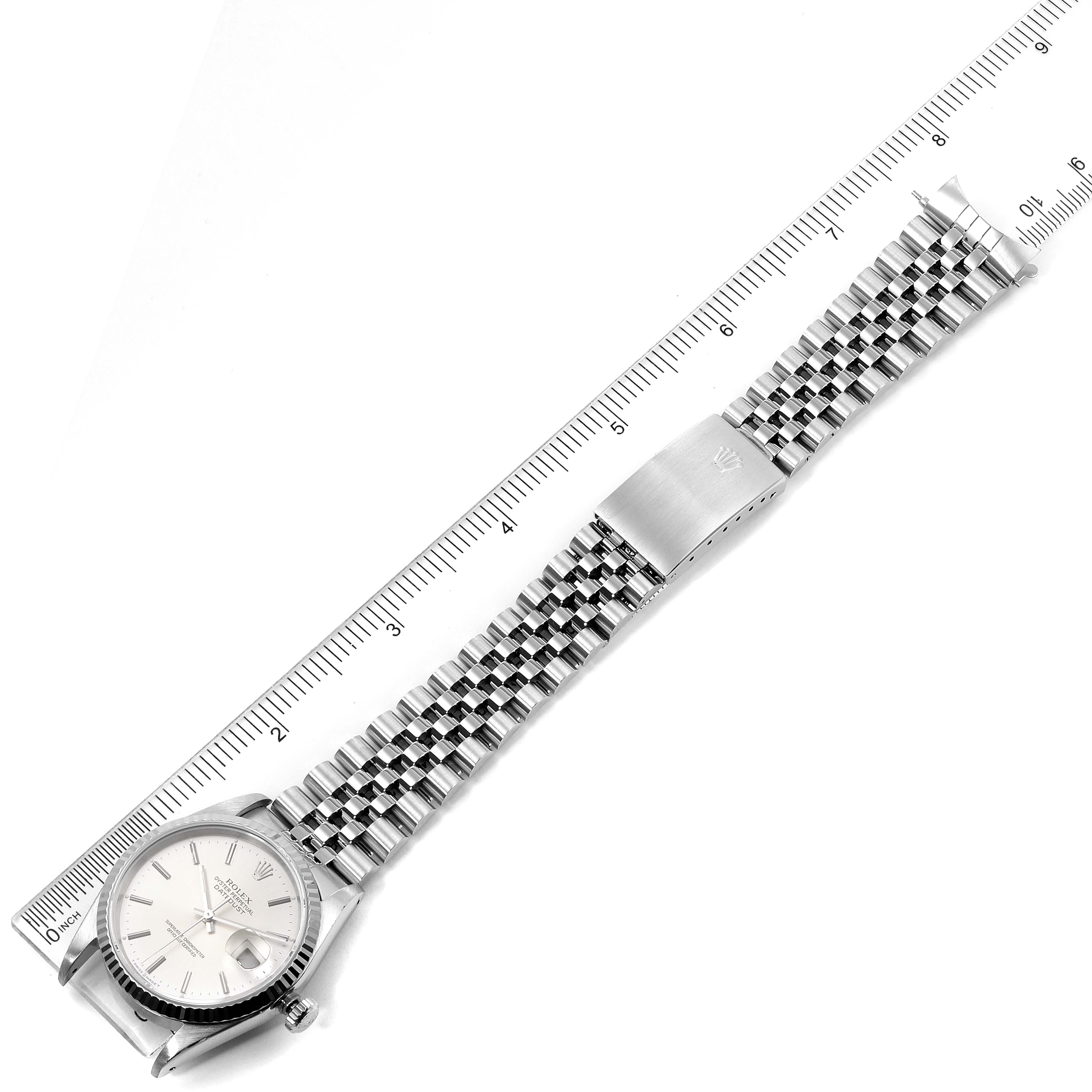 The image shows the Rolex Datejust 16234 Men's Stainless Steel Silver Dial 16234 Men's Stainless Steel Silver Dial watch laid flat with a ruler, displaying the face, bracelet, and clasp from a top view.