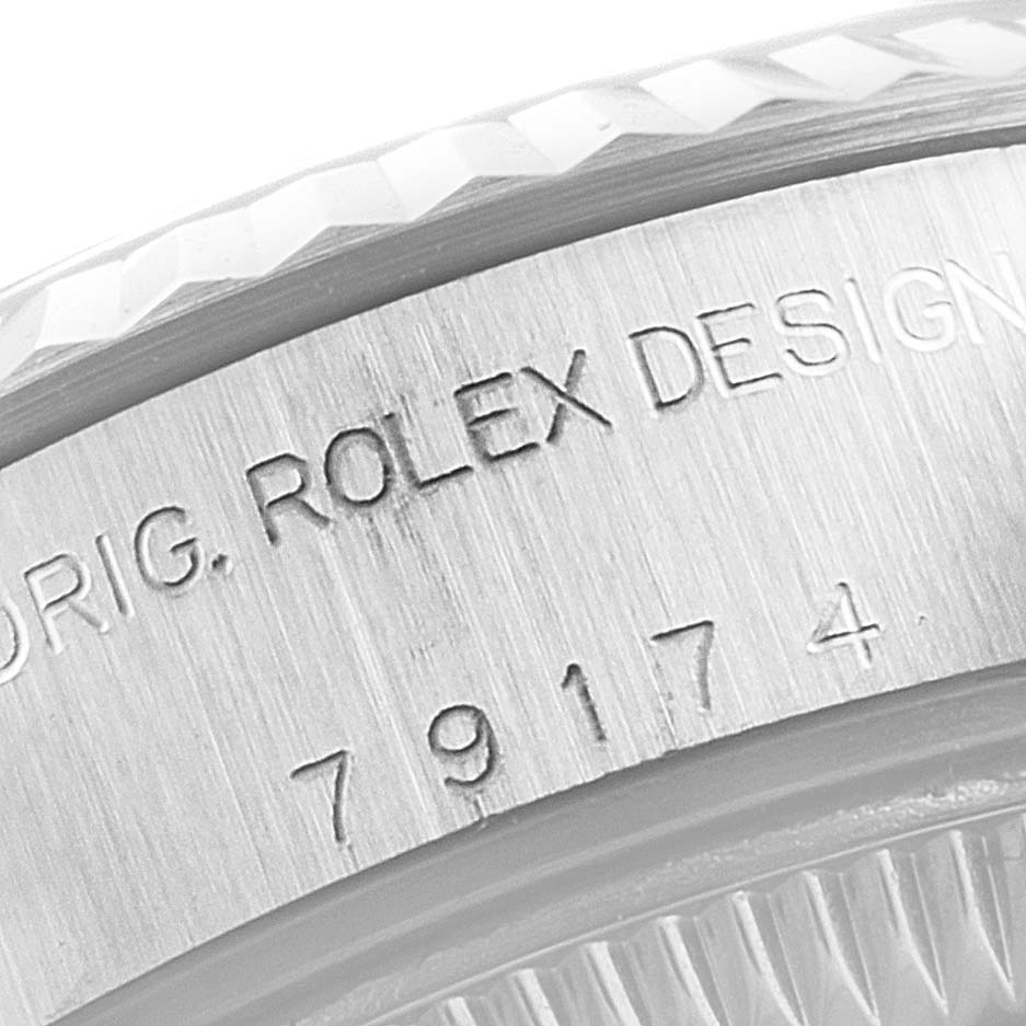 This image shows a close-up of the engraved serial number and fluted bezel on the Rolex Datejust 79174 Women's Stainless Steel Black Dial 79174 Women's Stainless Steel Black Dial model.