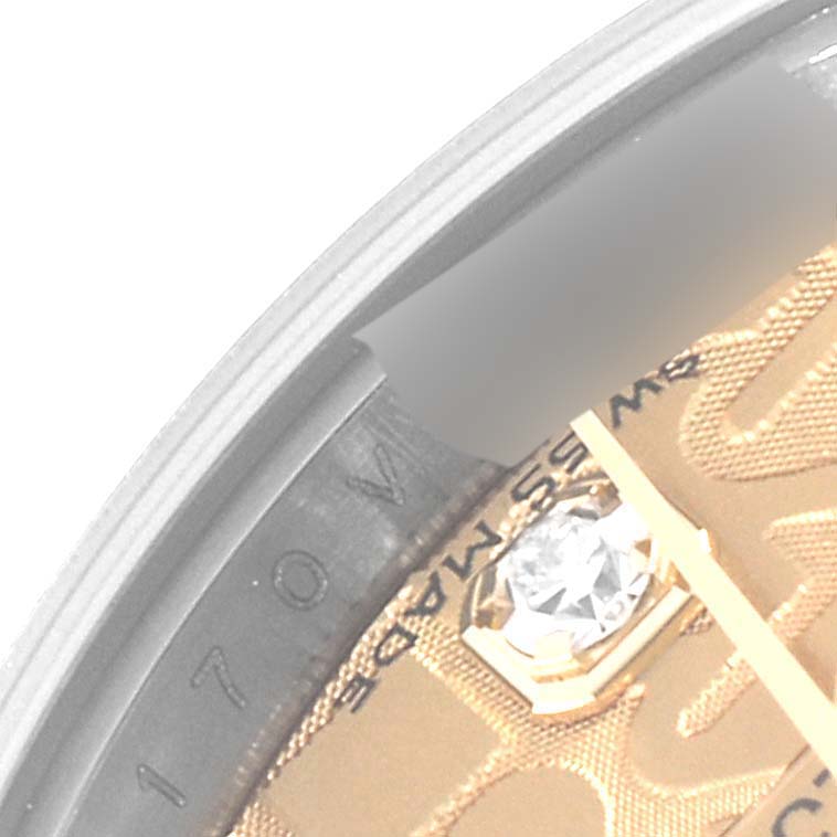 The image shows a close-up view of the dial and a section of the bezel of a Rolex Datejust 179173 Women's Steel and Gold (two tone) Champagne Dial 179173 Women's Steel and Gold (two tone) Champagne Dial, featuring a diamond and part of the text.