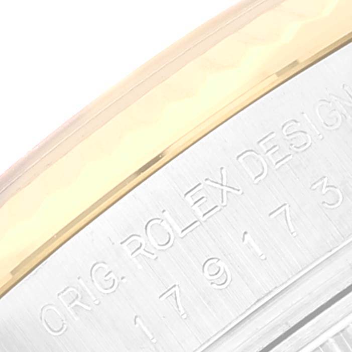 This image shows a close-up view of the side of a Rolex Datejust 179173 Women's Steel and Gold (two tone) Champagne Dial 179173 Women's Steel and Gold (two tone) Champagne Dial watch, highlighting the engraved text and edge of the bezel.