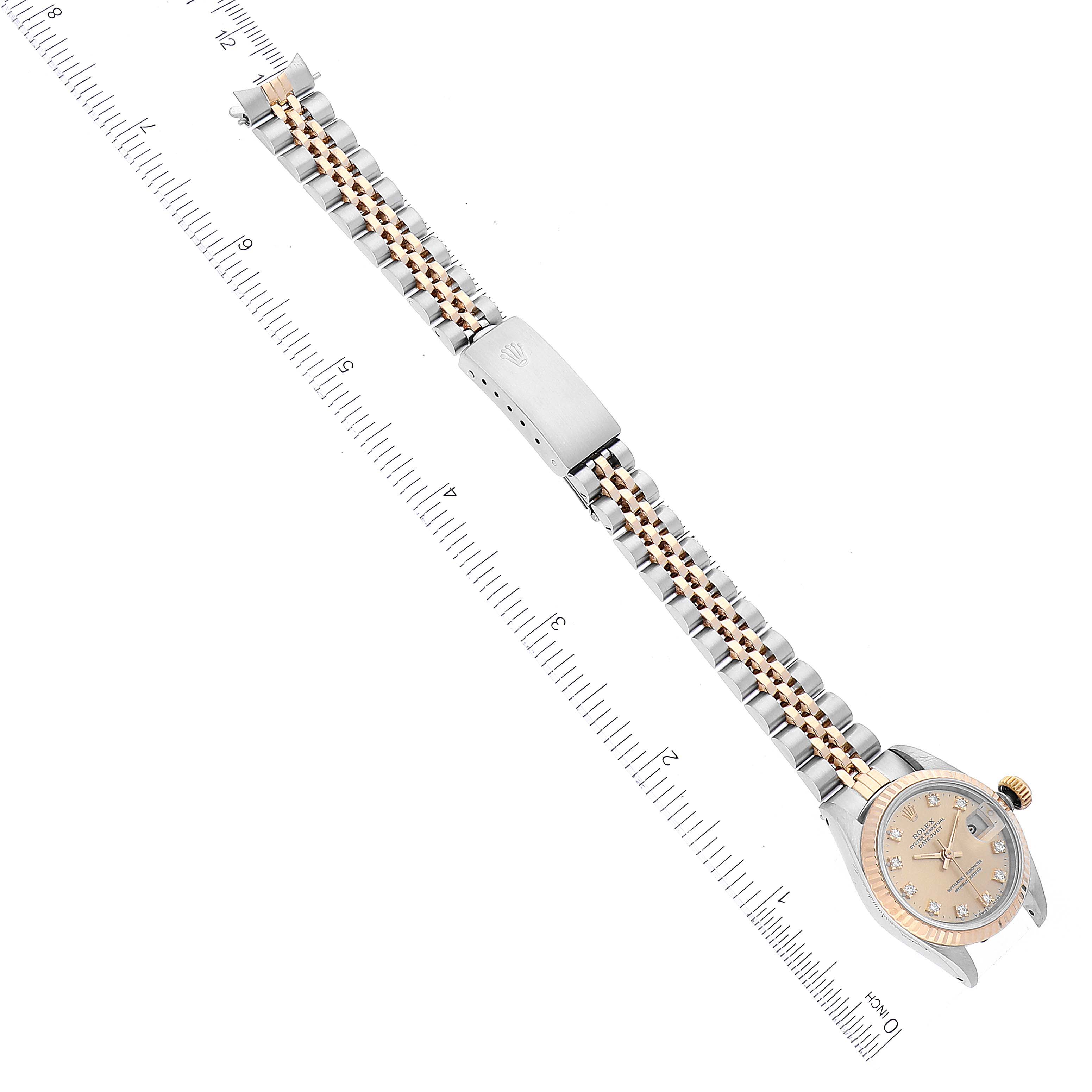 The image shows a top-down view of a Rolex Datejust 69173 Women's Steel and Gold (two tone) Champagne Dial 69173 Women's Steel and Gold (two tone) Champagne Dial watch, displaying its face, bracelet, and clasp, alongside a ruler for scale.