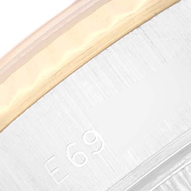 This close-up image of a Rolex Datejust 69173 Women's Steel and Gold (two tone) Champagne Dial 69173 Women's Steel and Gold (two tone) Champagne Dial watch shows a partial view of the bezel and case with some inscriptions.