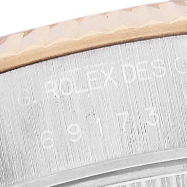 The image shows a close-up of the side of a Rolex Datejust 69173 Women's Steel and Gold (two tone) Champagne Dial 69173 Women's Steel and Gold (two tone) Champagne Dial model, focusing on its fluted bezel and engraved serial number.