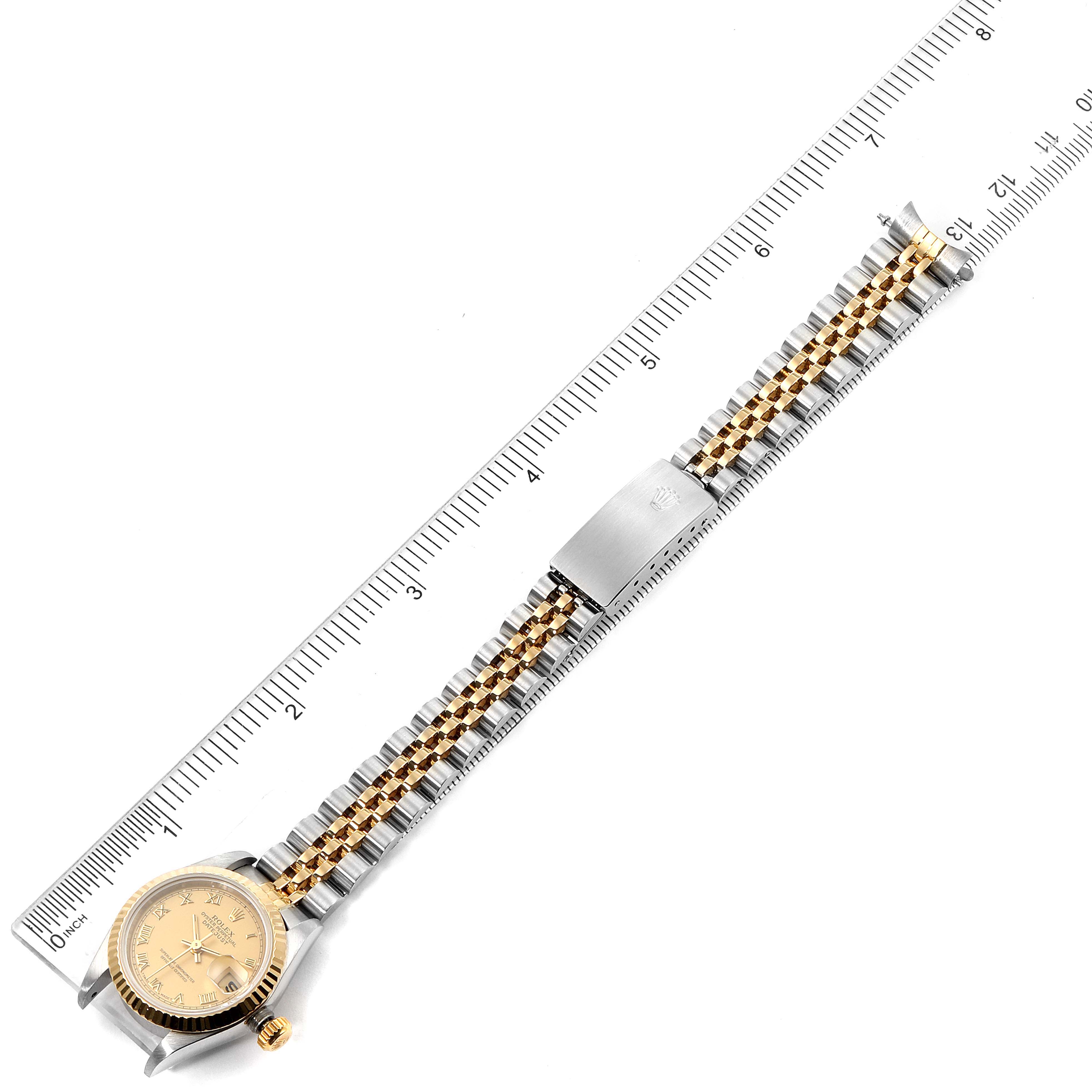 The Rolex Datejust 69173 Women
s Steel and Gold (two tone) Champagne Dial 69173 Women
s Steel and Gold (two tone) Champagne Dial watch is shown from the top angle, with its face, bracelet, and clasp visible, alongside a ruler for size reference.