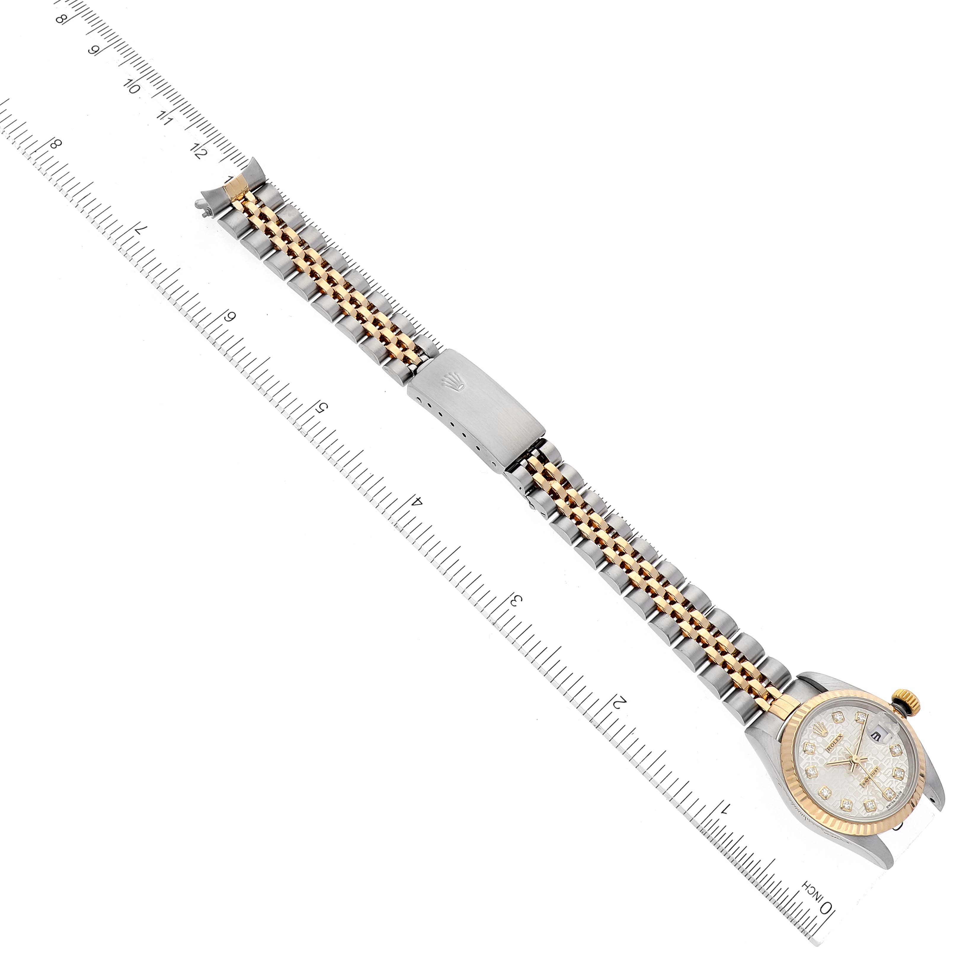 The image shows a Rolex Datejust 79173 Women's Steel and Gold (two tone) Silver Dial 79173 Women's Steel and Gold (two tone) Silver Dial watch laid flat at a diagonal angle, with measuring rulers on both sides.
