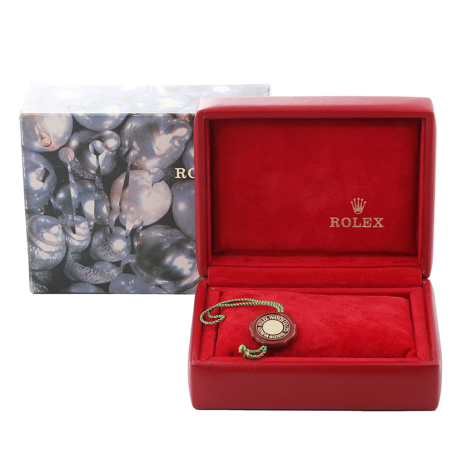 The image shows an open red Rolex watch box displaying a tag, with the outer packaging decorated with a pattern.