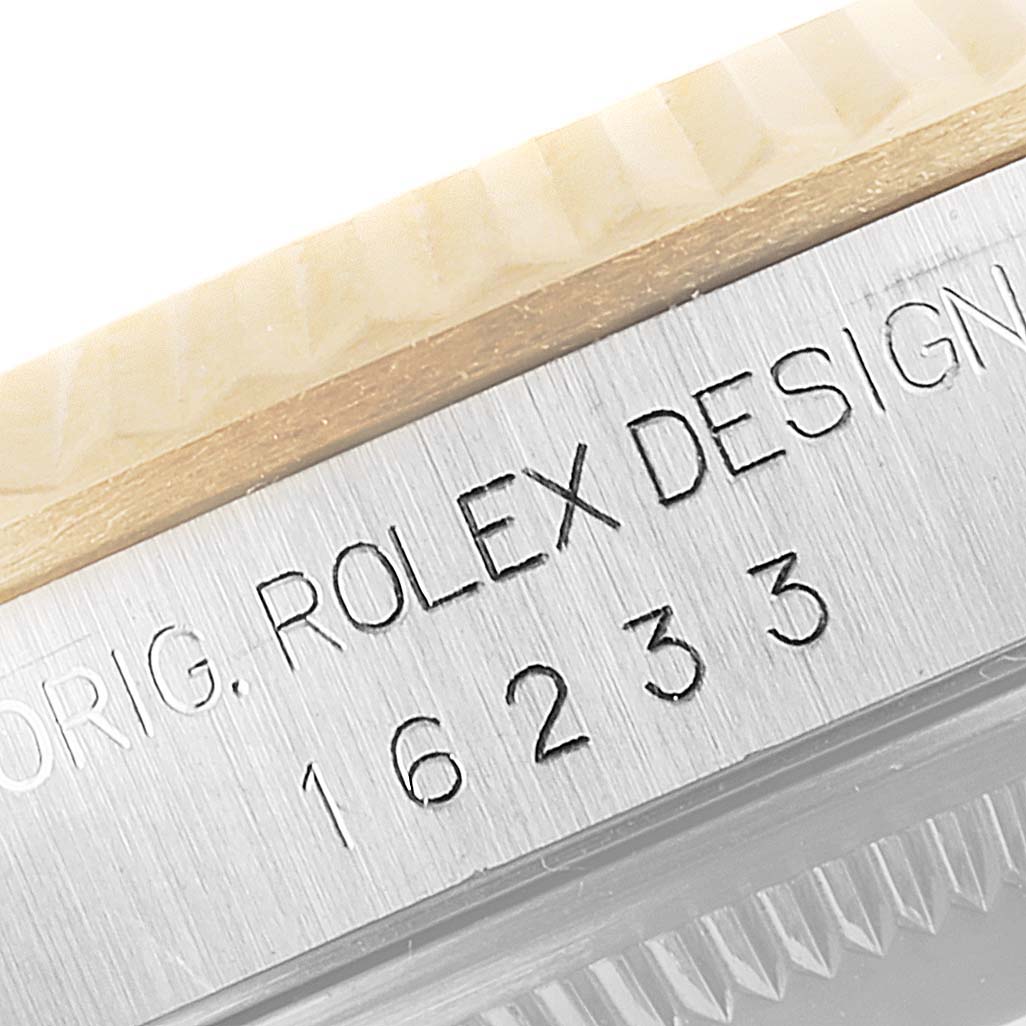 The image shows an engraved serial number "16233" and "ROLEX DESIGN" on the side of a Rolex Datejust 16233 Men's Steel and Gold (two tone) White Dial 16233 Men's Steel and Gold (two tone) White Dial watch case.
