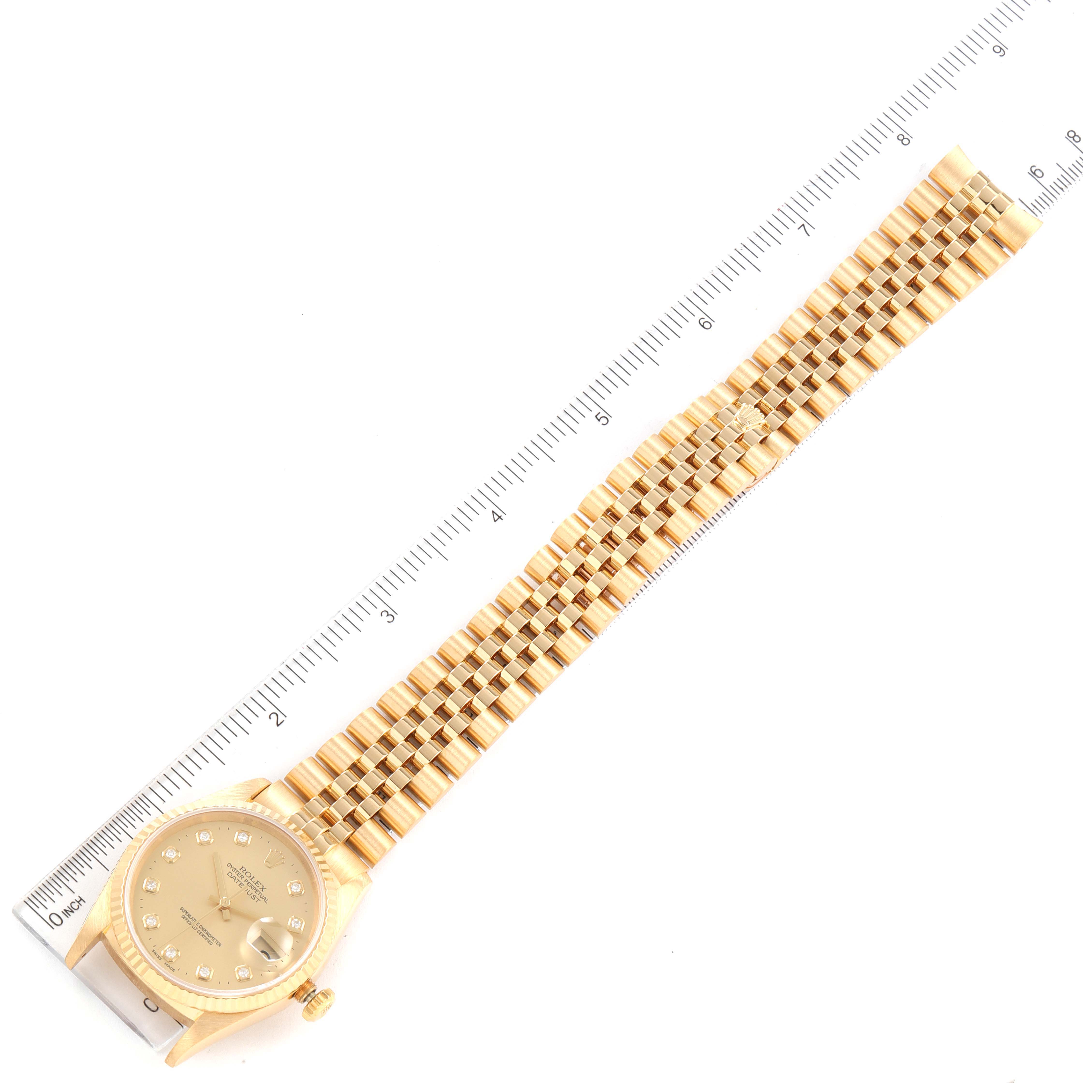 The image shows a top-down view of the entire Rolex President 16238 Men
s Yellow Gold Champagne Dial 16238 Men
s Yellow Gold Champagne Dial watch, including its face, band, and a measuring scale.