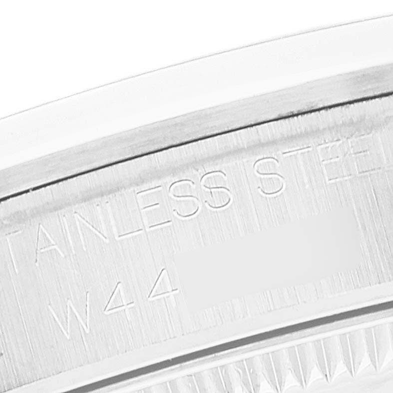 This image shows an angled close-up of the case back of a Mid-Size Rolex watch, highlighting the stainless steel engraving.
