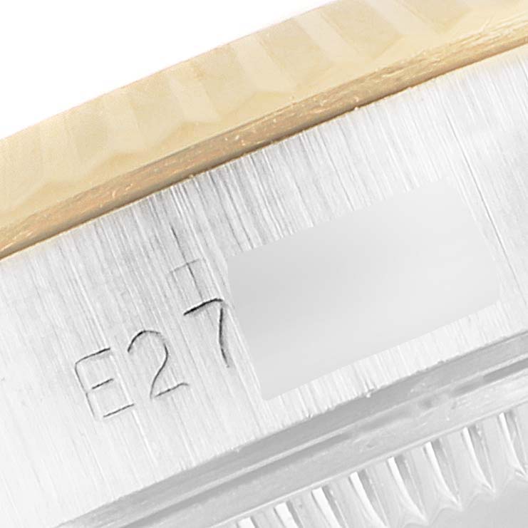 This image shows a close-up of the engraved edge of a Rolex Oyster Perpetual 67193 Women
s Steel and Gold (two tone) Champagne Dial 67193 Women
s Steel and Gold (two tone) Champagne Dial watch, focusing on the serial number area.