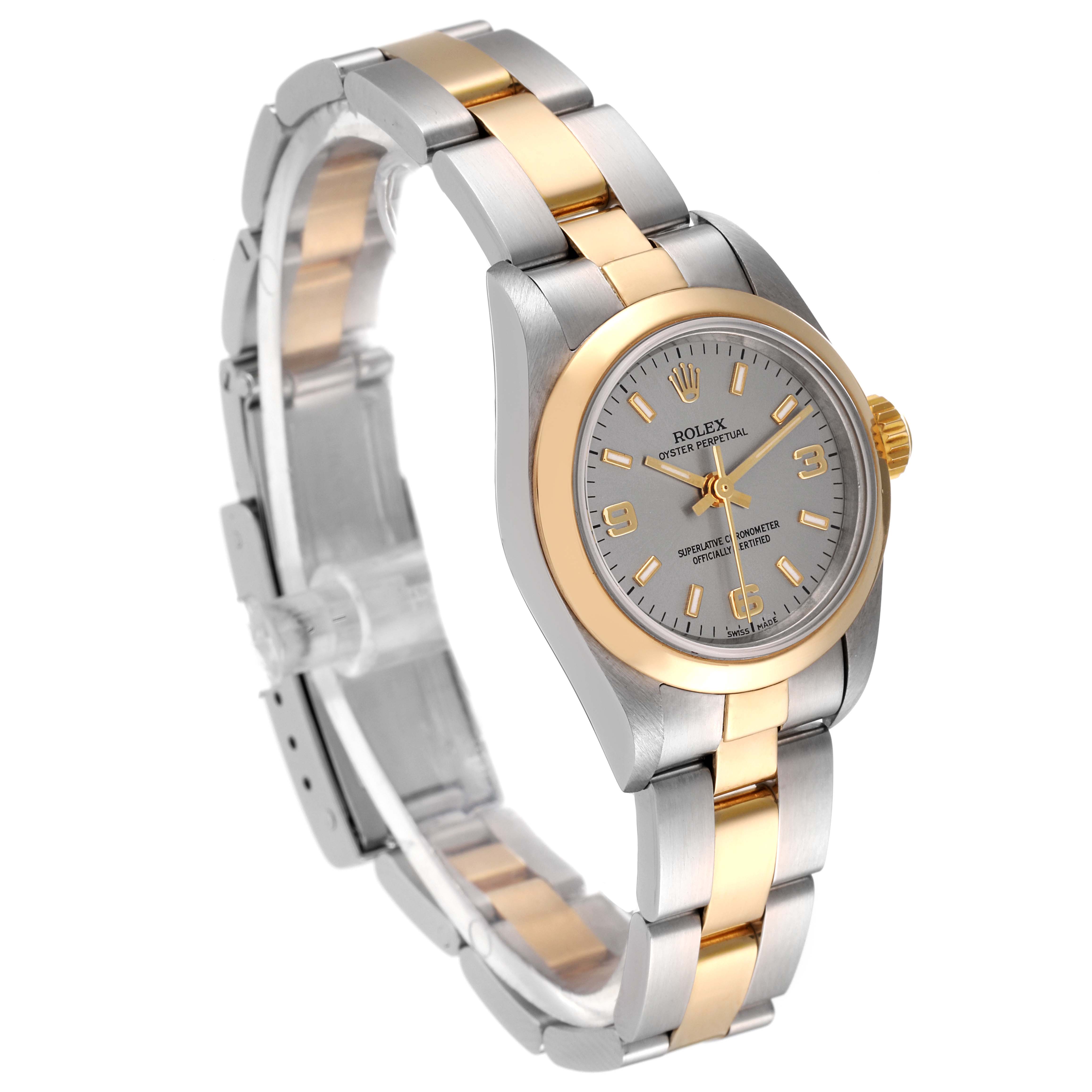 This Rolex Oyster Perpetual 67183 Women's Steel and Gold (two tone) Silver Dial 67183 Women's Steel and Gold (two tone) Silver Dial watch is shown at a three-quarter angle, highlighting its two-tone bracelet, bezel, and dial.