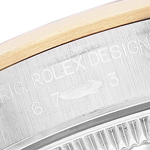 The image shows a close-up of part of the bezel and case of a Rolex Oyster Perpetual 67183 Women's Steel and Gold (two tone) Silver Dial 67183 Women's Steel and Gold (two tone) Silver Dial watch, highlighting the "ROLEX DESIGN" engraving.