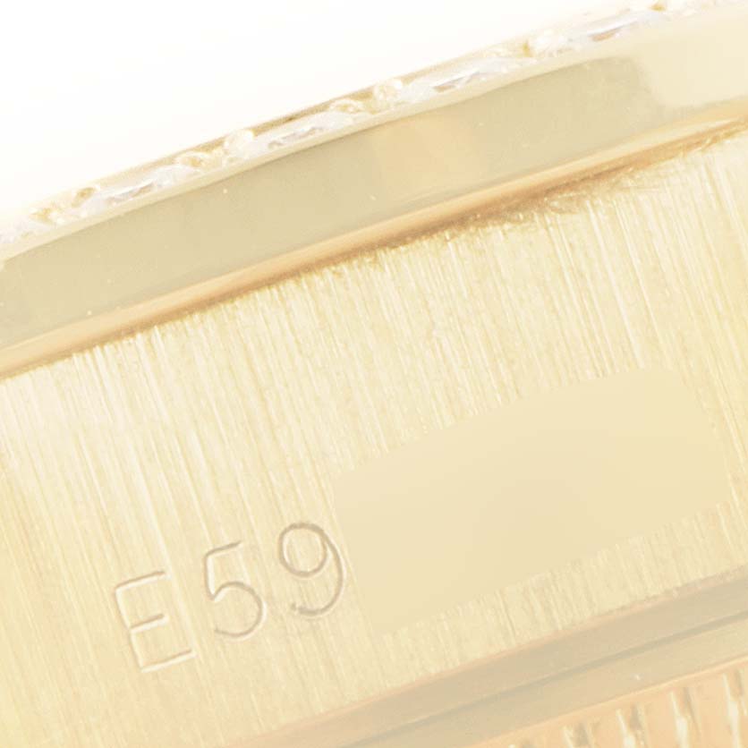 This close-up image shows a section of the case of a Rolex President 69138 Women
s Yellow Gold Champagne Dial 69138 Women
s Yellow Gold Champagne Dial model watch with a portion of the reference number visible.