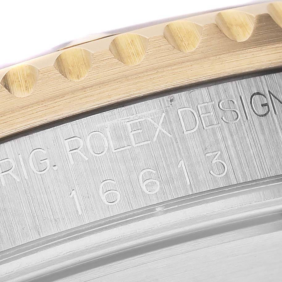 The image shows a close-up of the watch case edge of the Rolex Submariner 16613 Men
s Steel and Gold (two tone) Blue Dial 16613 Men
s Steel and Gold (two tone) Blue Dial model, highlighting the model number "16613."