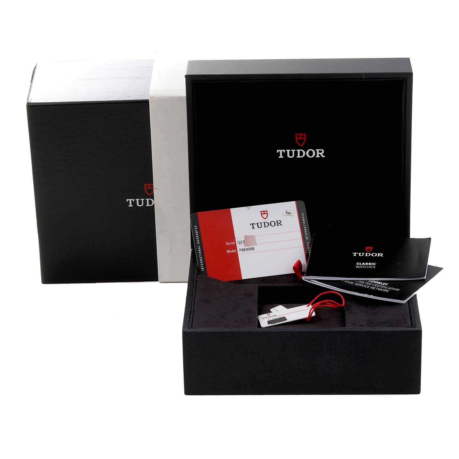 This image shows the packaging, warranty card, booklet, and tag of a Tudor Heritage Black Bay 79830RB Men
s Stainless Steel Black Dial 79830RB Men
s Stainless Steel Black Dial watch.