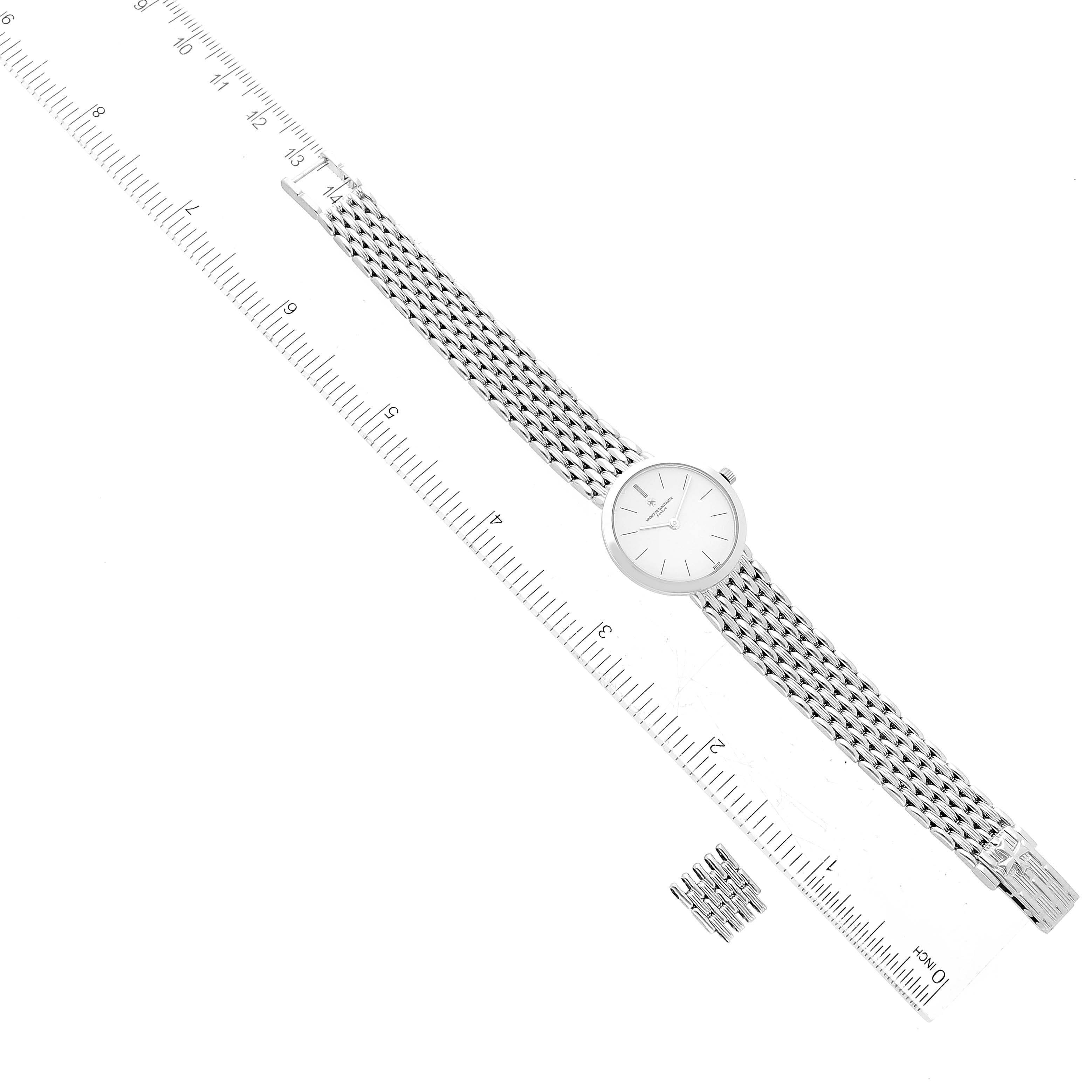 The Vacheron Constantin Traditionnelle 27093 Women
s White Gold White Dial 27093 Women
s White Gold White Dial watch is shown from a top view alongside a few spare bracelet links and a ruler for scale.