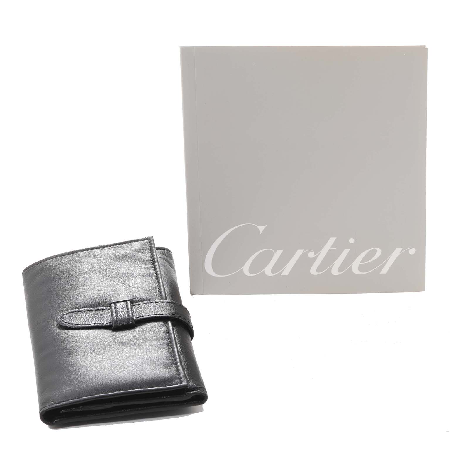 The image shows a Cartier Roadster W62020X6 Men's Stainless Steel Black Dial W62020X6 Men's Stainless Steel Black Dial watch's leather pouch and a Cartier branded booklet.