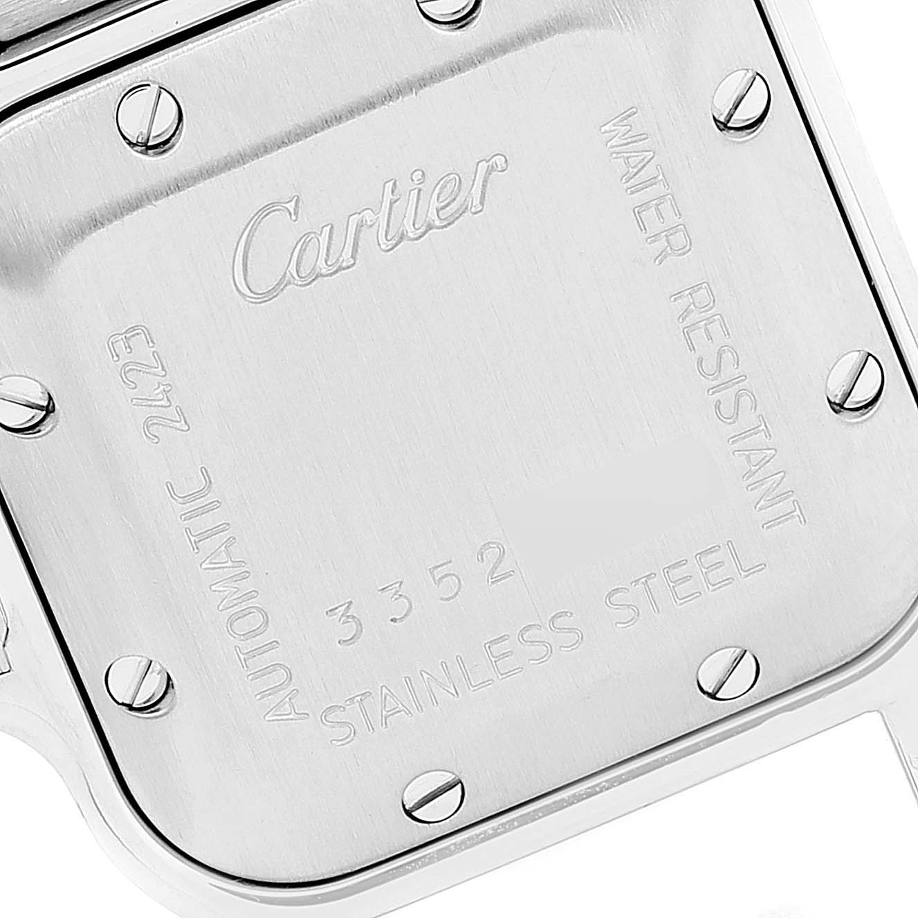 The image shows the stainless steel case back of a Santos model by Cartier, including its engraved details and screws.