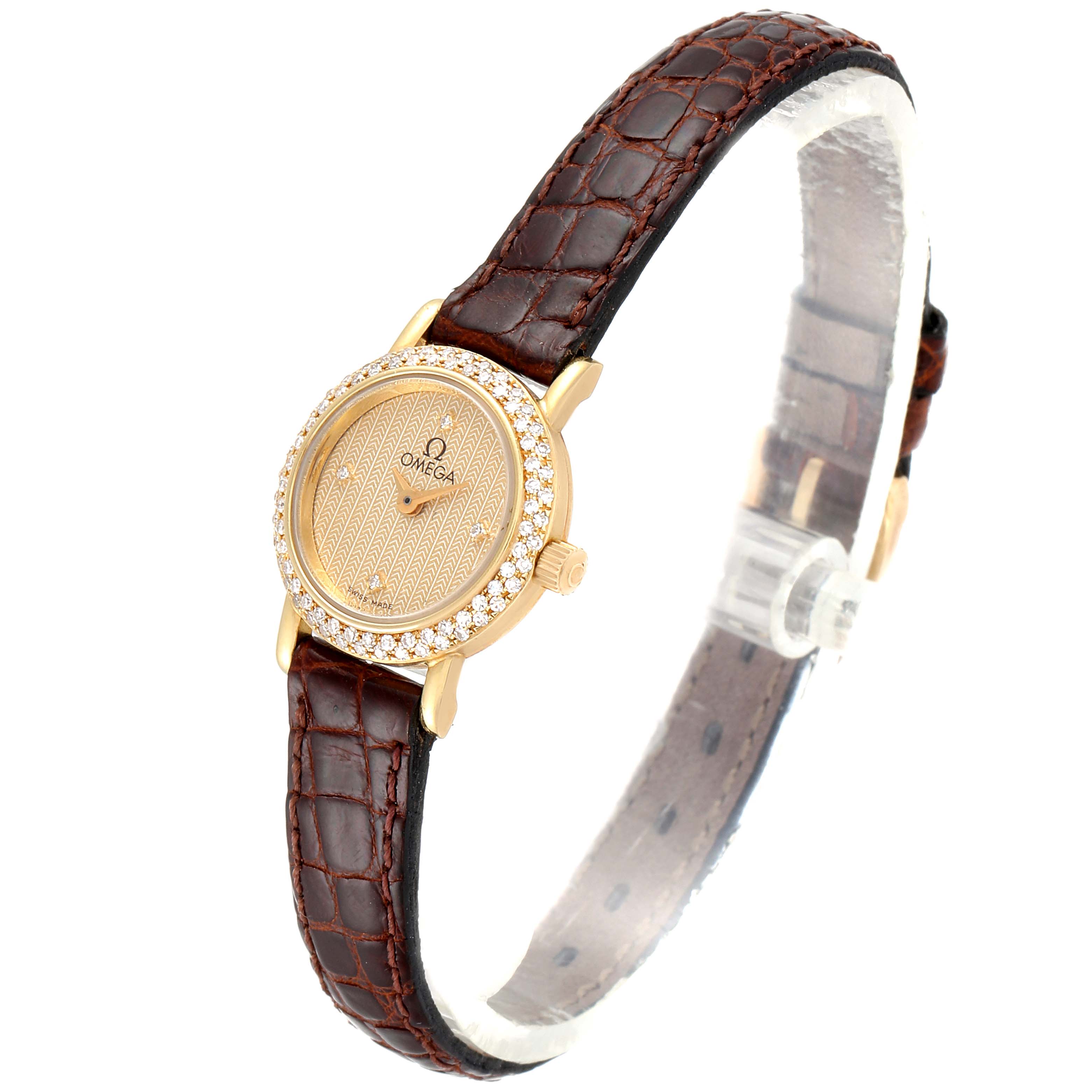 The image shows the Omega 1450 Women's Yellow Gold Champagne Dial 1450 Women's Yellow Gold Champagne Dial DeVille Mini Yellow Gold Diamond Cocktail Ladies Watch 1450 Unworn model from a 3/4 angle, highlighting its gold dial and leather strap.