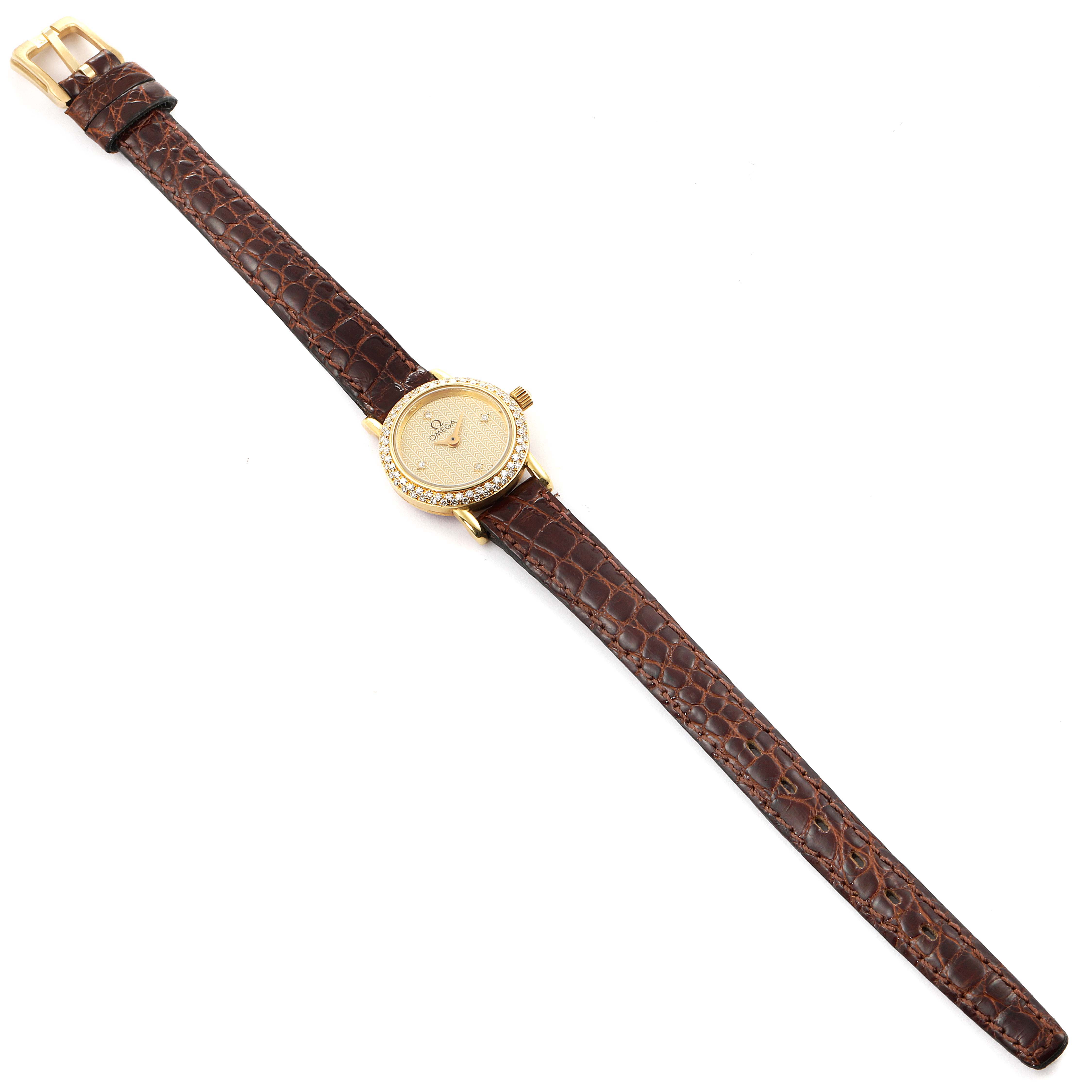 The image shows an overhead view of the Omega 1450 Women's Yellow Gold Champagne Dial 1450 Women's Yellow Gold Champagne Dial DeVille Mini Yellow Gold Diamond Cocktail Ladies Watch 1450 Unworn model with a brown leather strap.