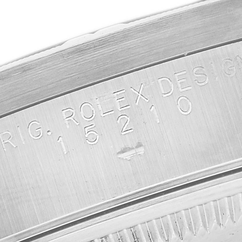 The image shows a close-up of the engraved serial number and bezel of a Rolex Date 15210 Men's Stainless Steel Blue Dial 15210 Men's Stainless Steel Blue Dial model watch.