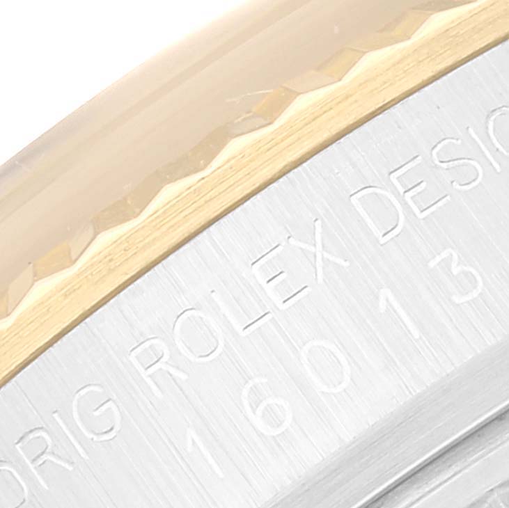 This close-up image shows part of the bezel and case of a Rolex Datejust 16013 Men's Steel and Gold (two tone) Champagne Dial 16013 Men's Steel and Gold (two tone) Champagne Dial, featuring its engraved model number.