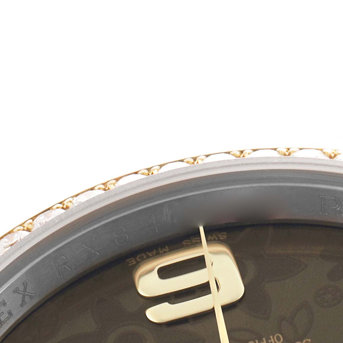 The image shows a close-up of the bezel, part of the dial, and hour marker of the Rolex Datejust 116243 Men's Steel and Gold (two tone) Brown Dial.