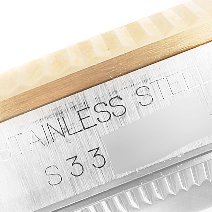 This close-up image of the Mid-Size Rolex watch shows the outer edge of the bezel and part of the stainless steel casing.