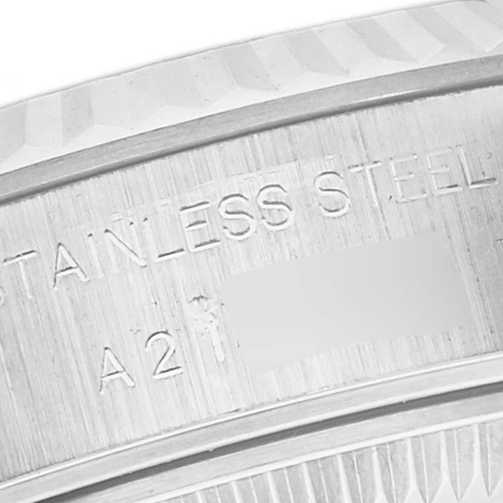 This image shows a close-up of the engraved side of the bezel on a Rolex Datejust 79174 Women's Stainless Steel Pink Dial 79174 Women's Stainless Steel Pink Dial watch, displaying text and serial numbers.